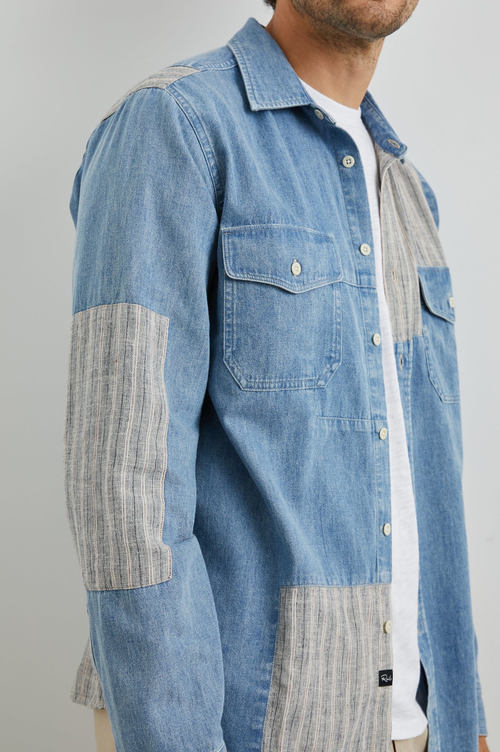 Larsen Long-Sleeve Button Up with Two Chest Button Flap Pockets in Medium Indigo Patchwork Colorway, Denim Patches and Vertical Stripes in Grey and White - Front Unbuttoned View Featured on Model