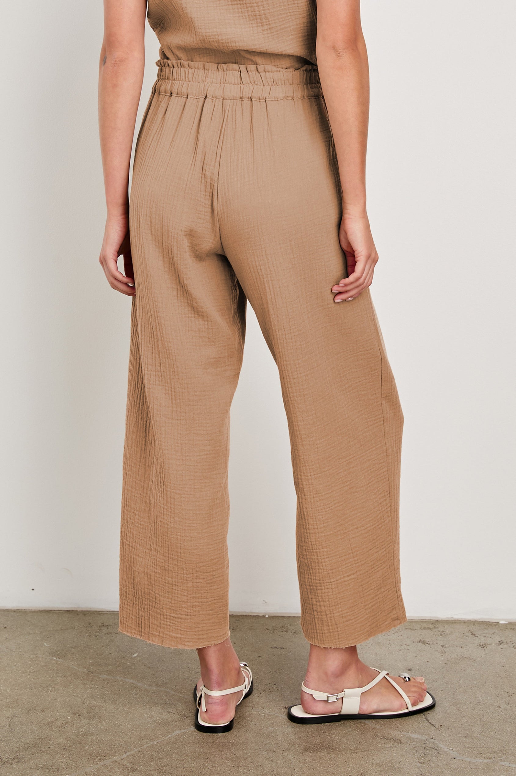 Leon Crop Cotton Gauze Pant With Hemline Slit And Elastic Waist In Colorway Taupe - Back View Featured On Model