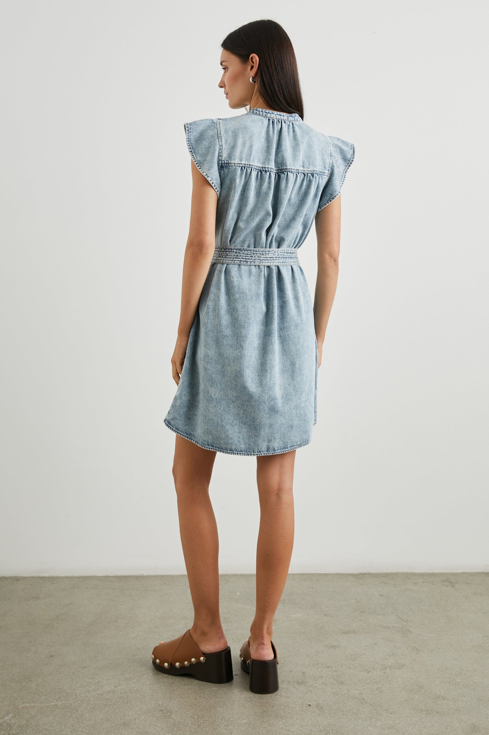 Letta Above-Knee Dress with Flutter Sleeves, Snaps down the Front, and a Belted Waist in Faded Indigo Colorway - Back Full Body View Featured on Model