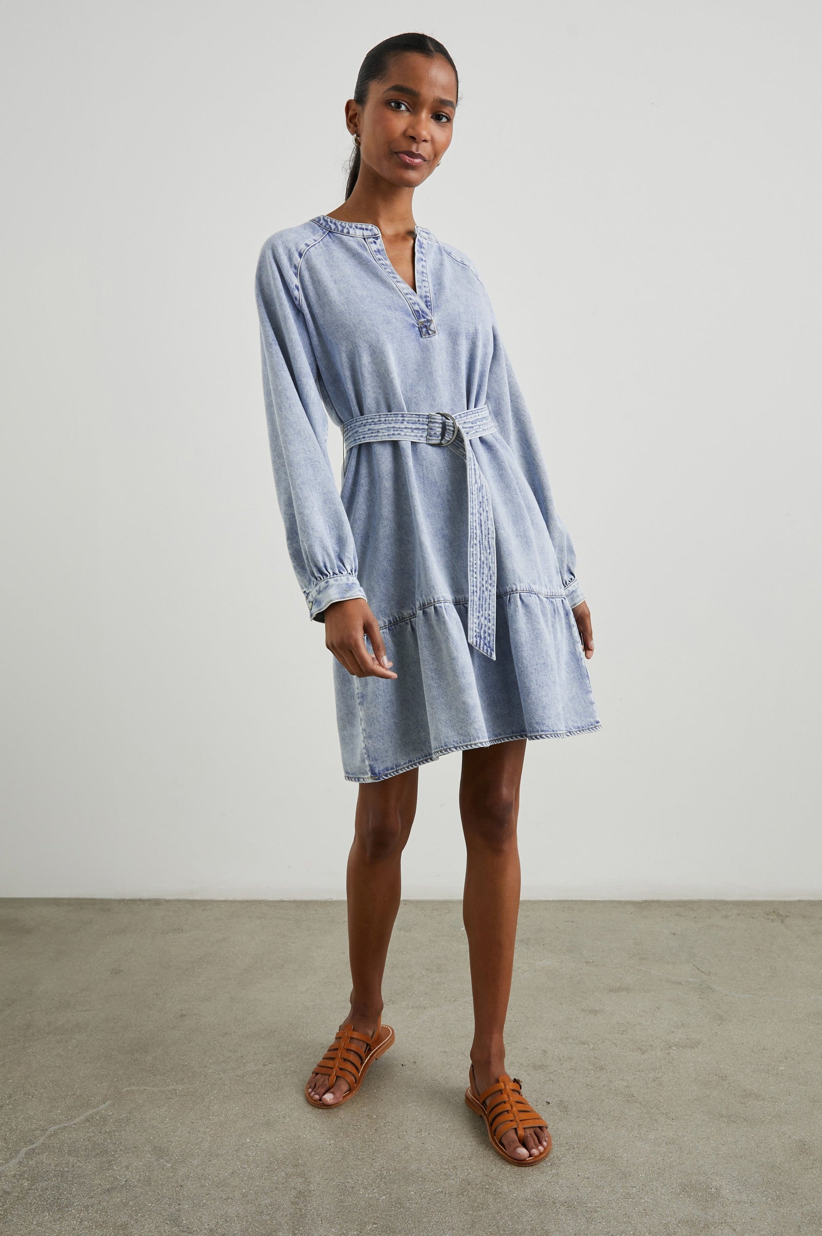 Lila Long-Sleeve Denim Mini Dress with a Fabric Double Ring Belt, a V Neck and Snap Cuffs in Faded Indigo Colorway - Front Full Body View Featured on Model