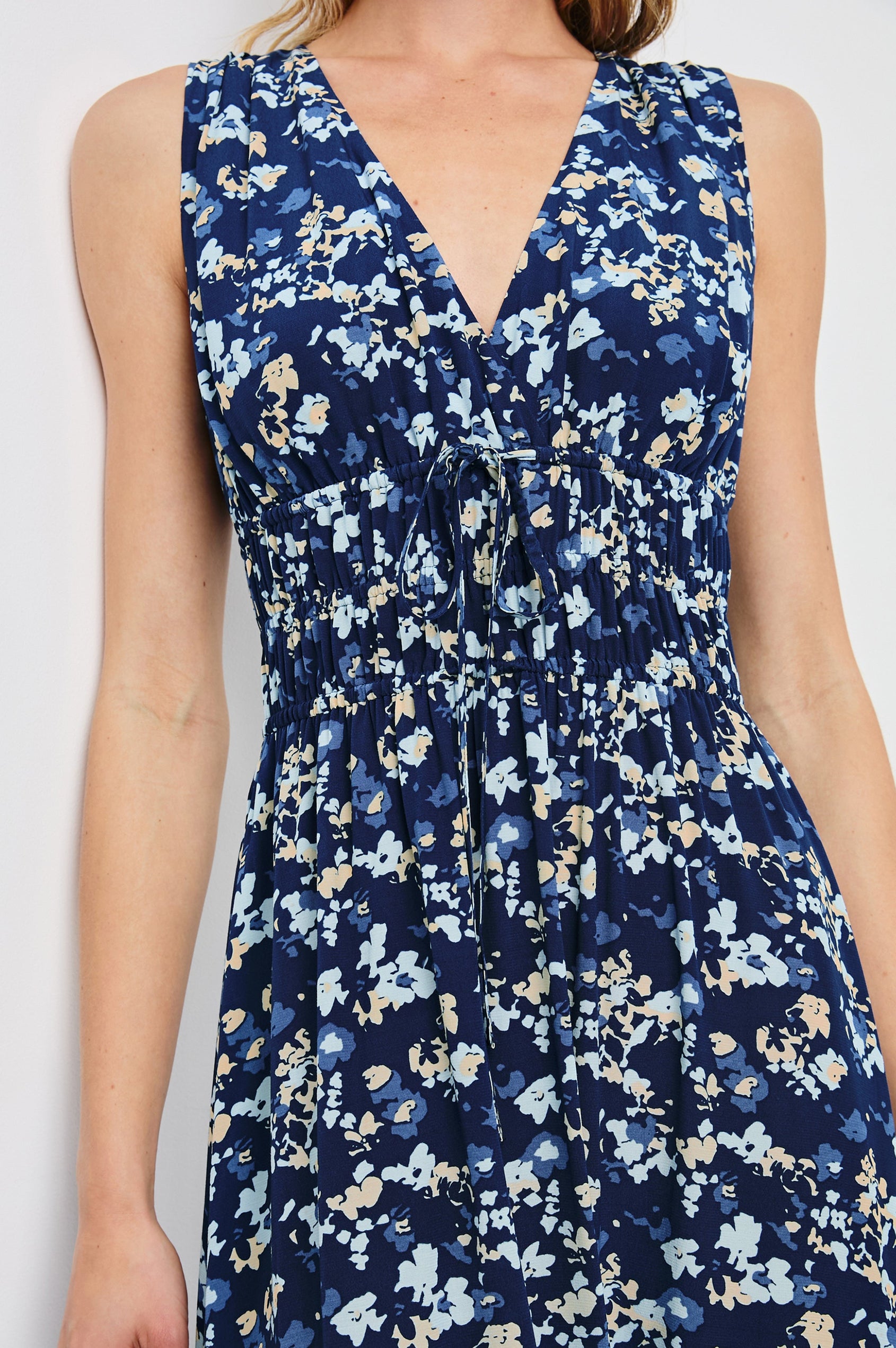 Lilith Sleeveless Midi Dress with Wide Shoulder Straps, a Deep V neck, a Cinched Waist with Drawstring, and a Back Neck Tie in Navy Flora Colorway, with flowers in creams and blues on Navy - Front View Featured on Model