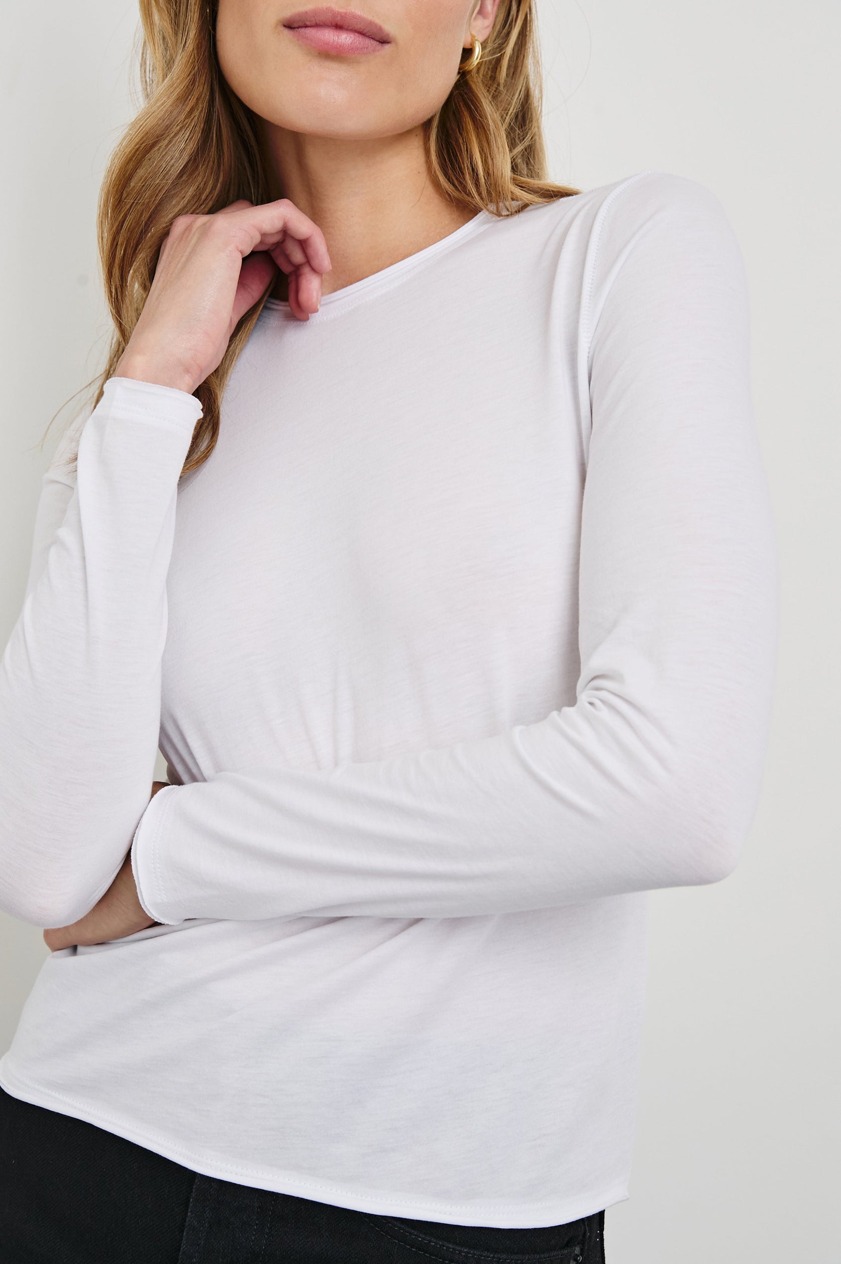 Long Sleeve Crew Neck T Shirt with Raw Hem, Collar and Cuffs in White Colorway - Front View Featured on Model