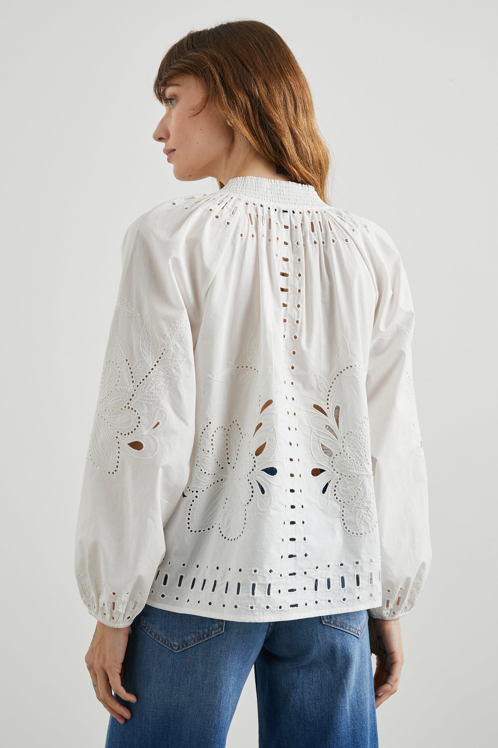Lucinda Long-Sleeve Top with Billowy Sleeves, a V Neck with a Drawstring Collar, and a Floral and Geometric Eyelet Design in White Colorway - Back View Featured on Model