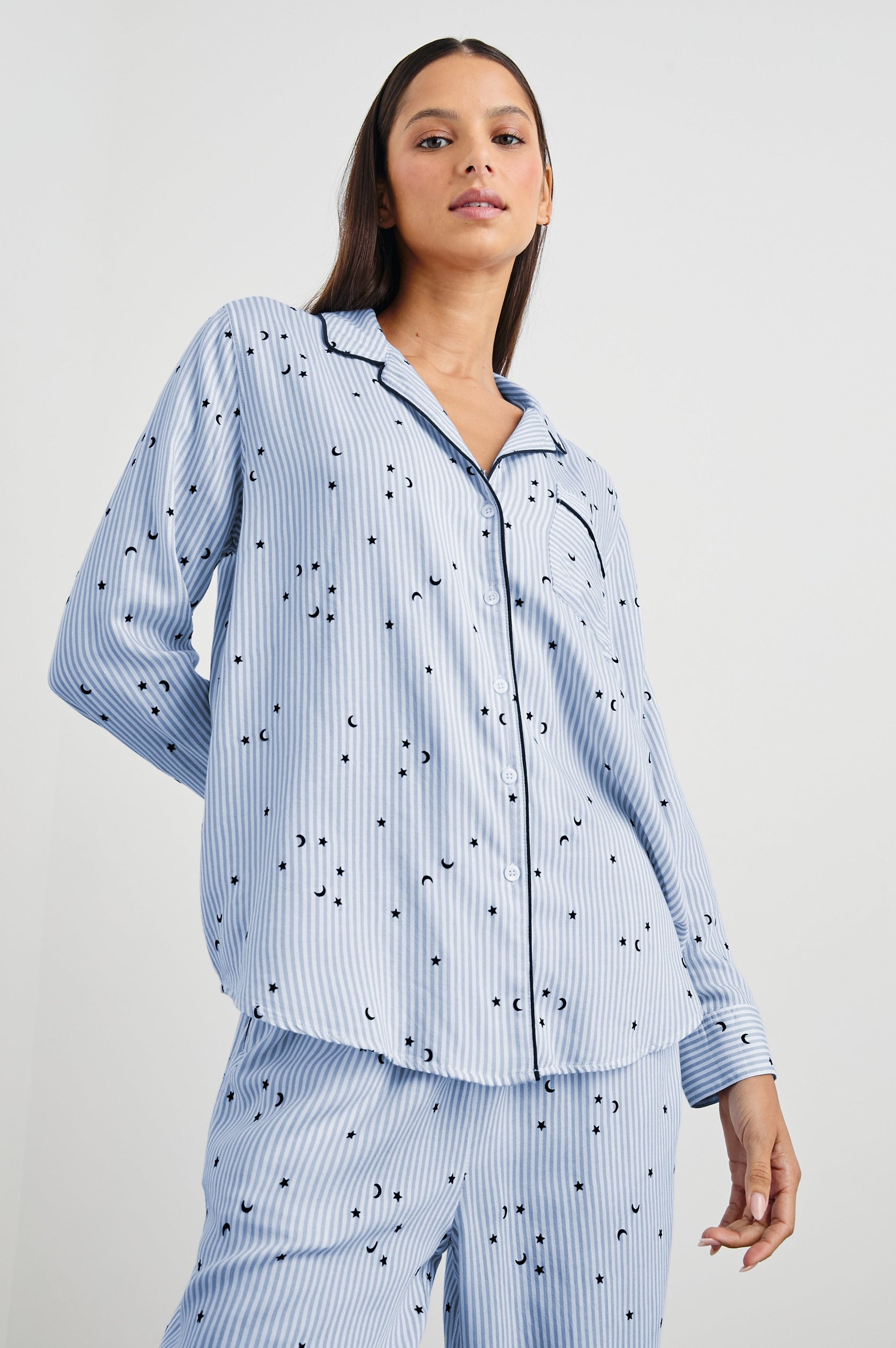 Luna Pajama Set with a Long Sleeve, Button Up, V Neck Top with a Chest Patch Pocket and Pants with Two Front Pockets in Flocked Cosmic Stripe Colorway, Black Moons and Stars on Blue and White Vertical Stripe - Front View Featured on Model