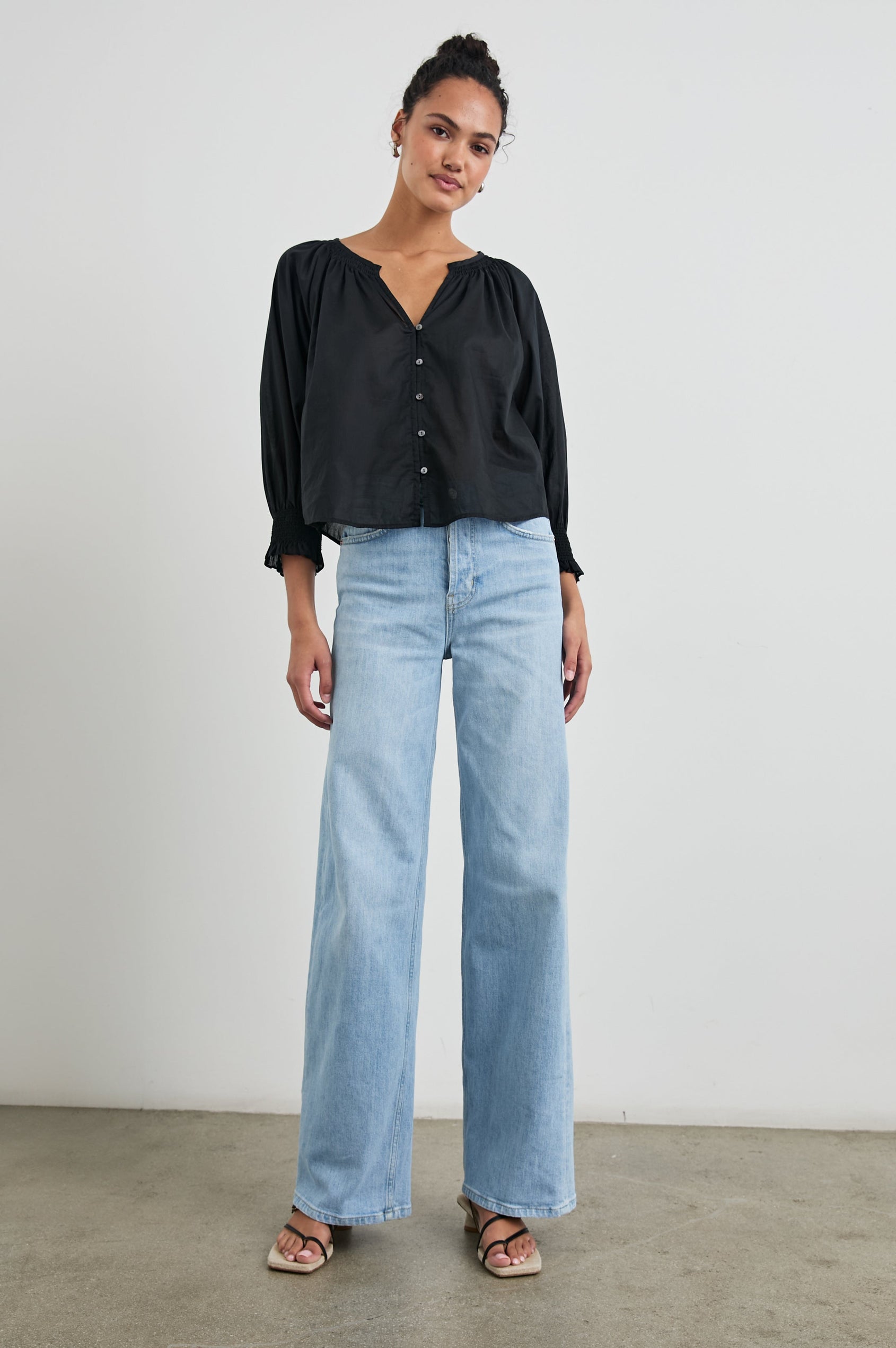 Mariah Top with Three-Quarter Sleeves, Shirred Cuffs, V-Neckline, and Buttons Down the Front in Black Colorway - Front Full Body View Featured on Model