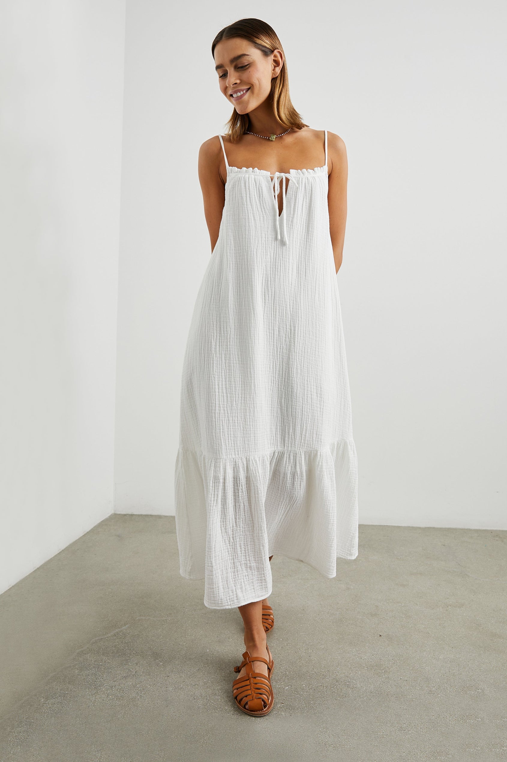 Marseille Midi Dress with Adjustable Spaghetti Straps, a Deep V Neck with a Tie, and a Lightly Ruffled Hem in White Colorway - Front Full Body View Featured on Model