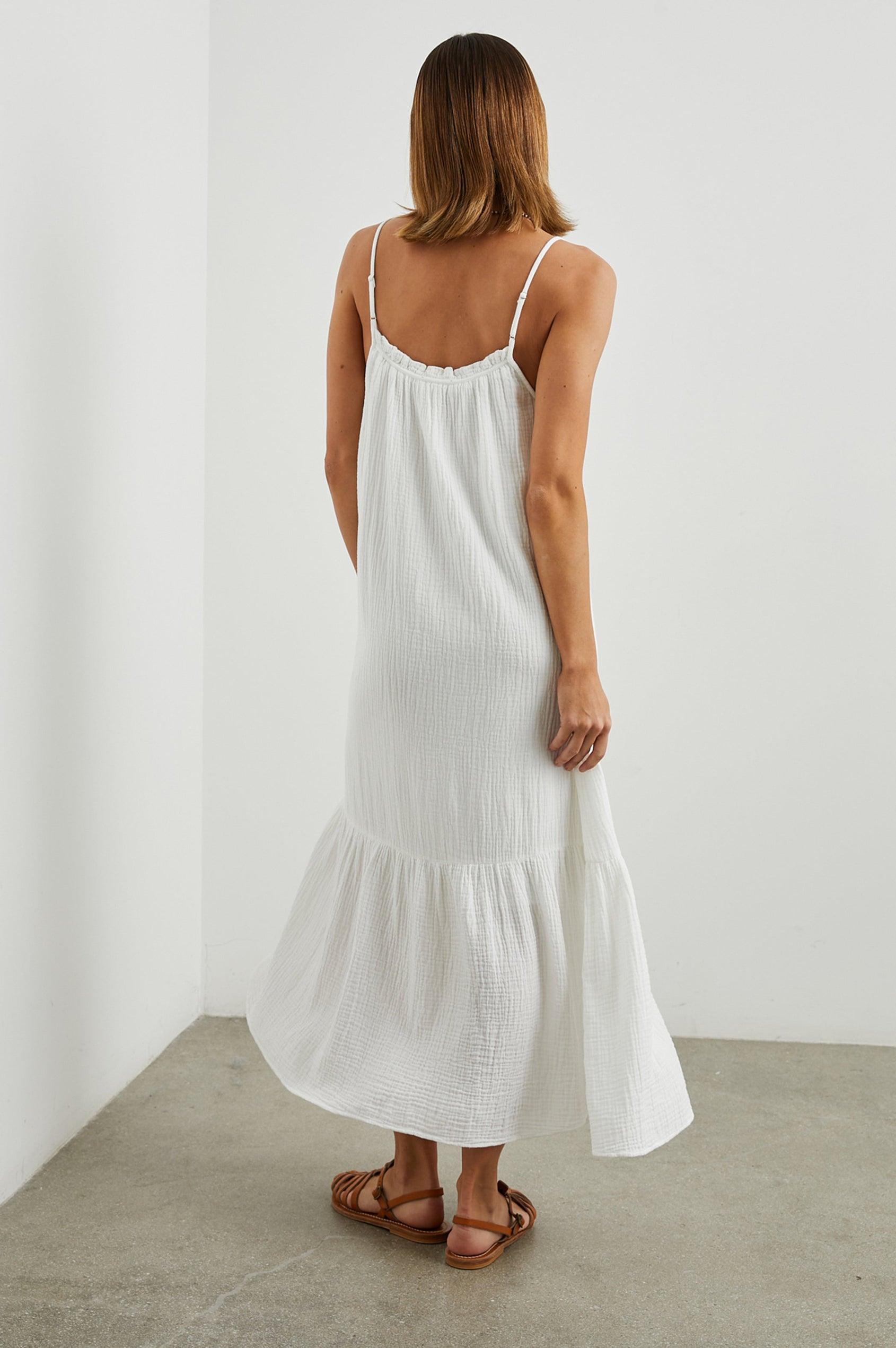 Marseille Midi Dress with Adjustable Spaghetti Straps, a Deep V Neck with a Tie, and a Lightly Ruffled Hem in White Colorway - Back Full Body View Featured on Model
