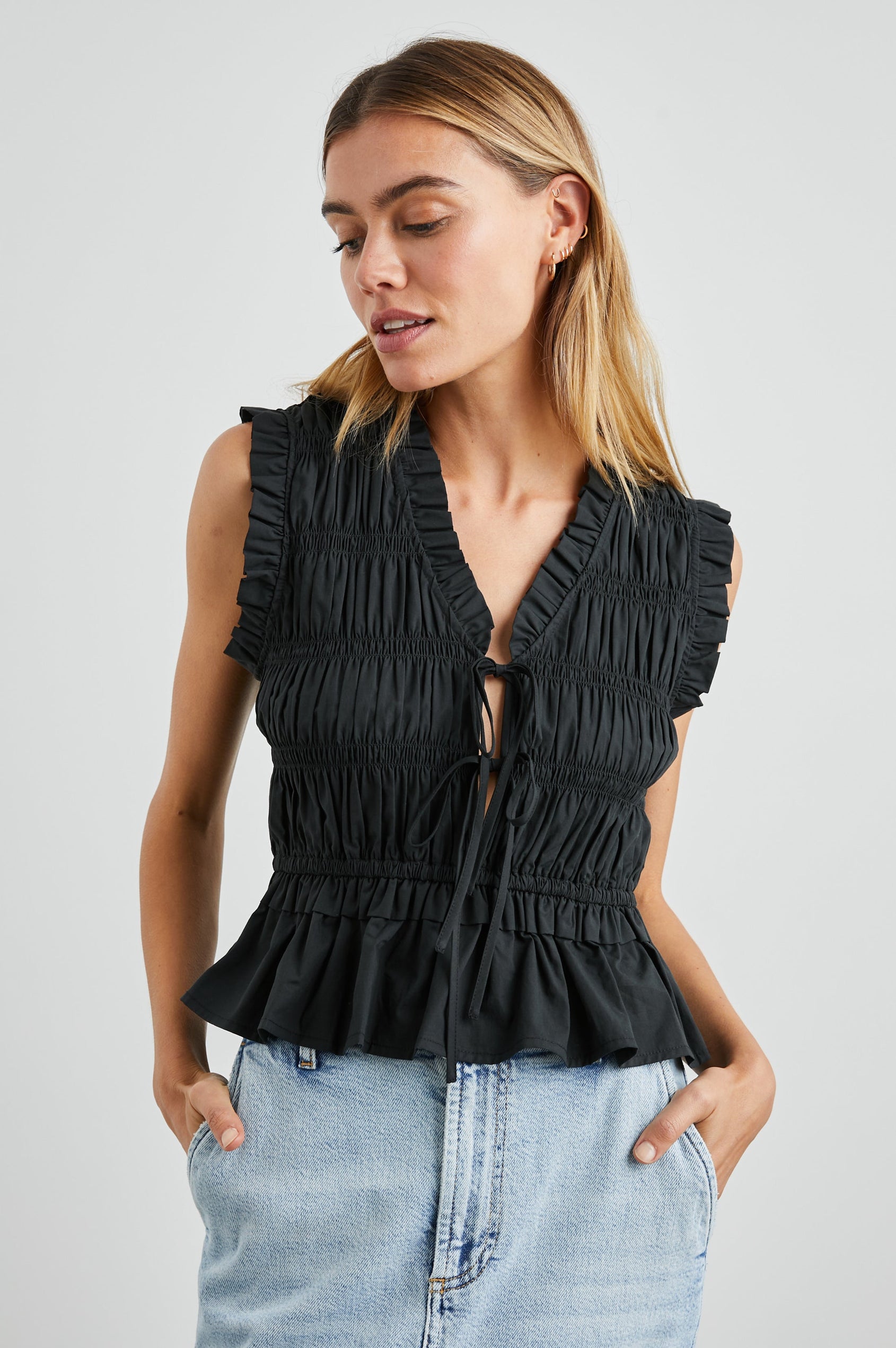 Martine Sleeveless Top with Ruffled Trim, a Deep V-Neck with Ties and Smocking in Black Colorway - Front View Featured on Model