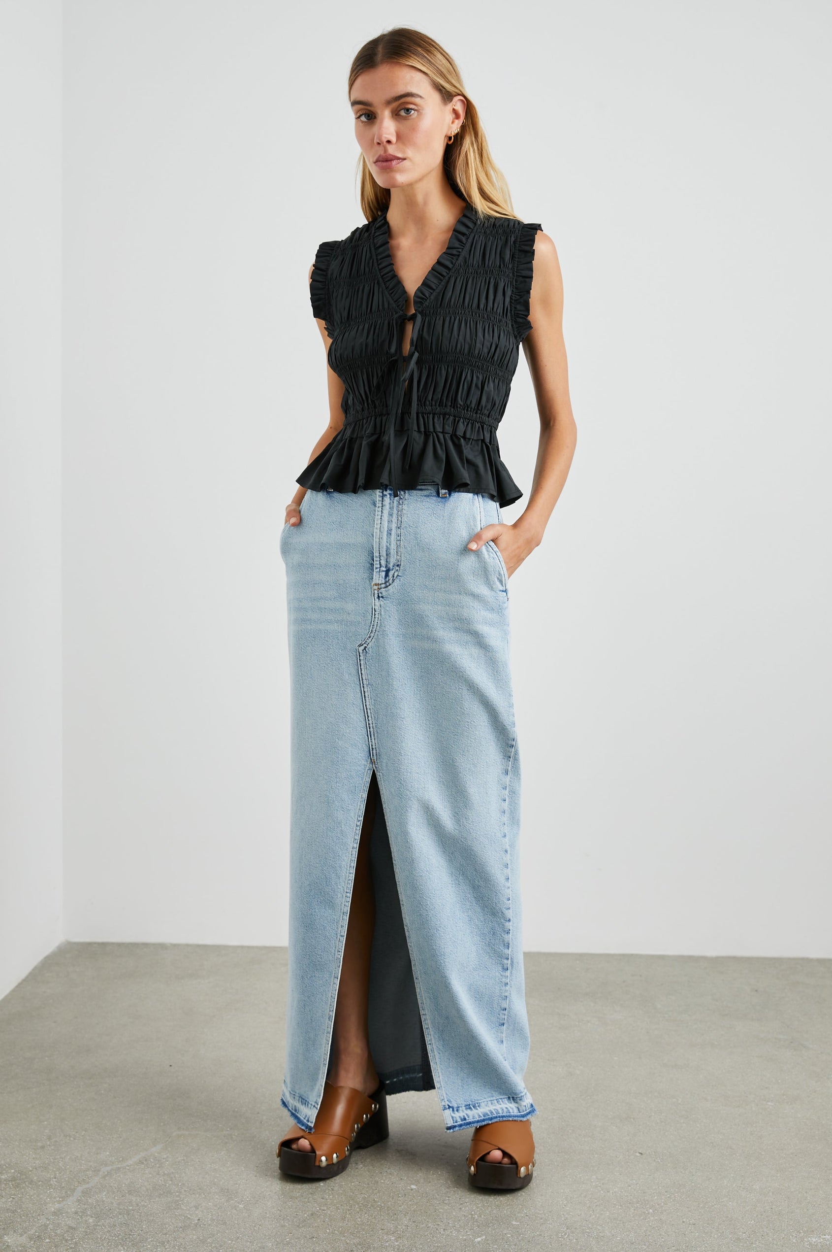 Martine Sleeveless Top with Ruffled Trim, a Deep V-Neck with Ties and Smocking in Black Colorway - Front Full Body View Featured on Model
