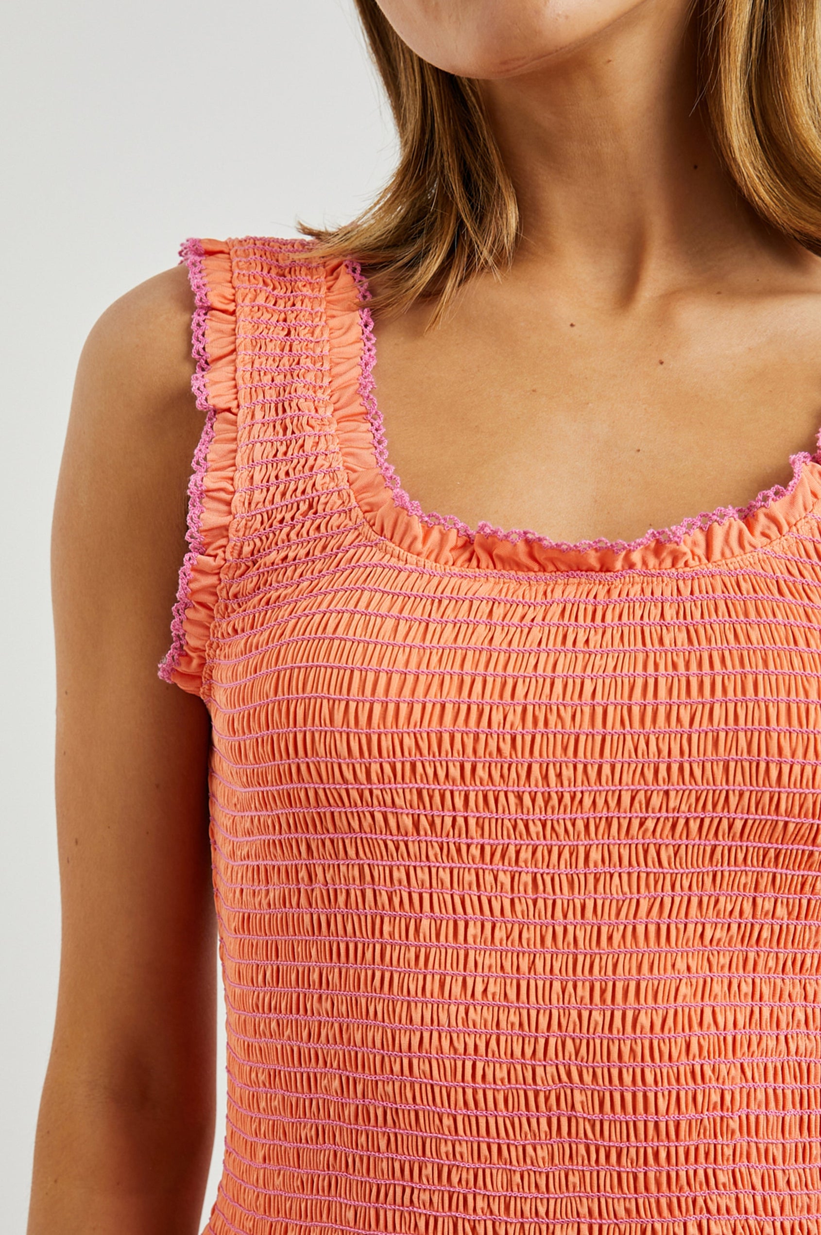 Maxine Crop Tank with Smocking Throughout and Ruffled Trim in Papaya Colorway, with Pink Stitching Details - Front View Featured on Model