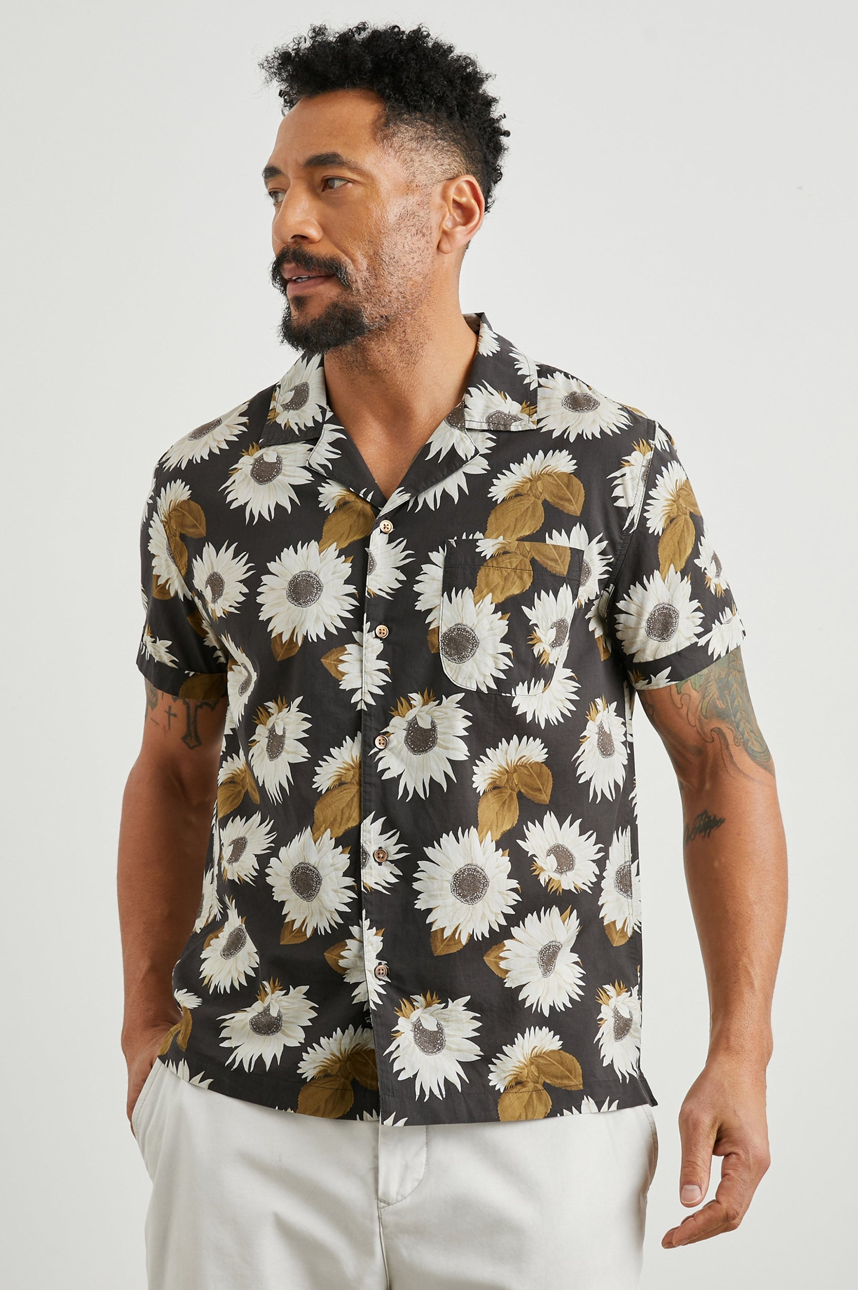 Moreno Short Sleeve Button Up with a Chest Patch Pocket in Sunflower Twirl Bark Colorway, White Sunflowers and Brown Leaves on Black - Front View Featured on Model