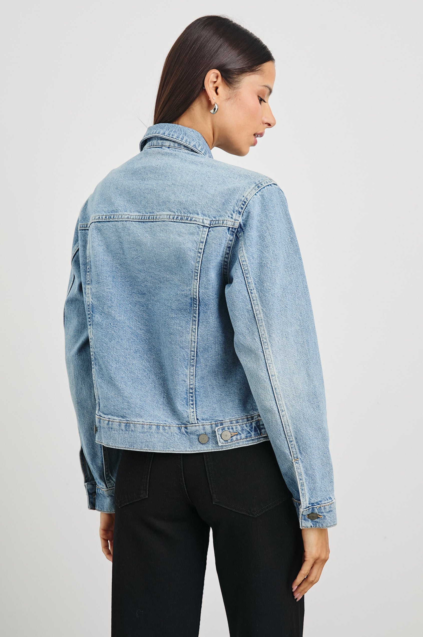 Mulholland Denim Jacket with Button Closure, Two Chest Button Flap Pockets, Two Front Pockets, Adjustable Button Straps on Hem in Original Blue Colorway - Back View Featured on Model