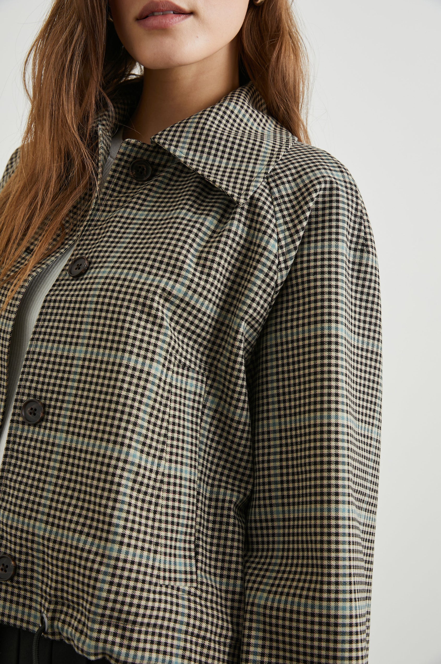 North Cropped Jacket with Button Closure, Puff Sleeves, Oversize Collar, a Toggle Hem, Two Front Pockets and a Horizontal Back Vent in Teal Multi Check Colorway, a Black, Tan and Teal Plaid - Front View Featured on Model