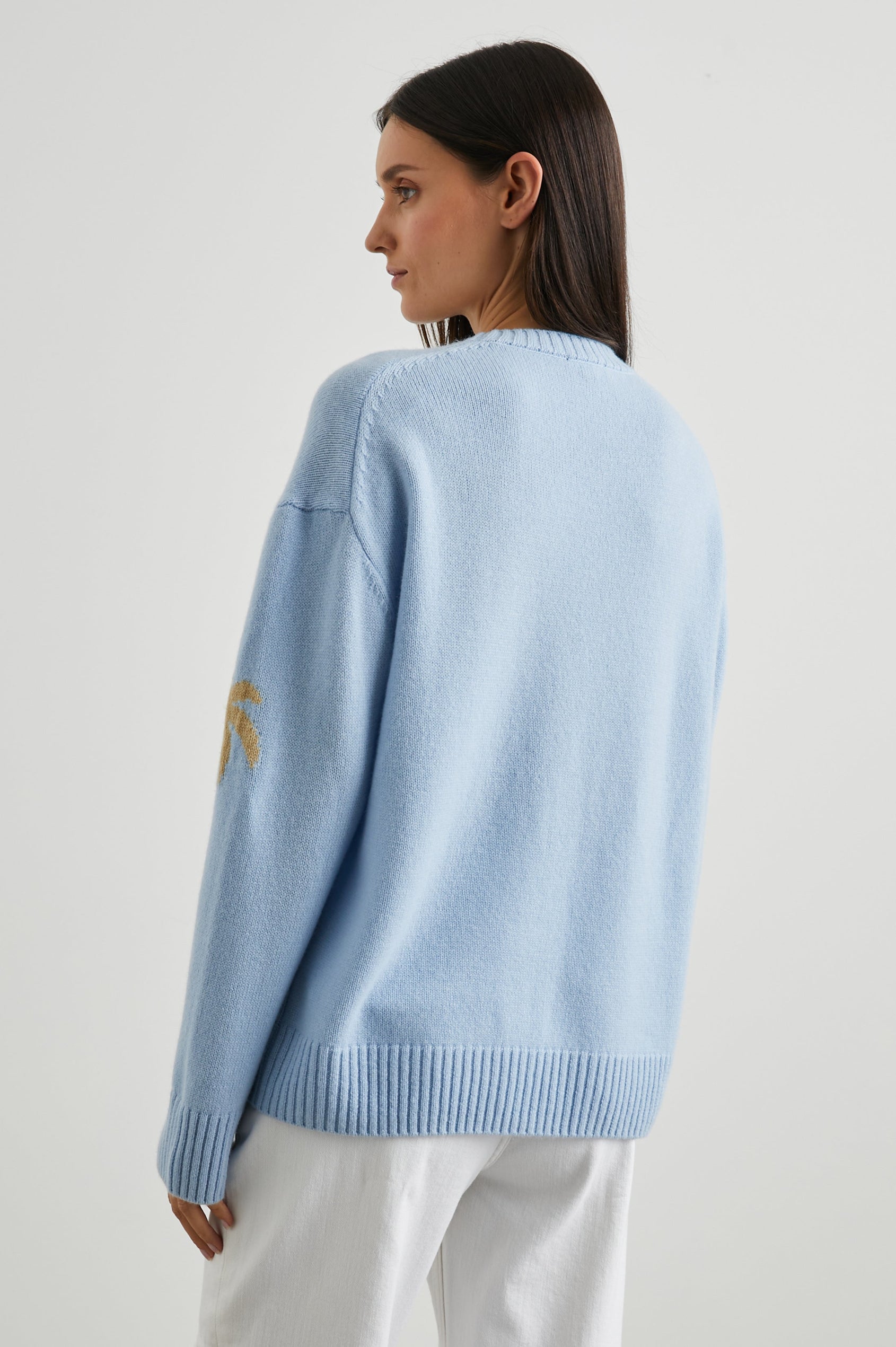 Olivia Long-Sleeve Sweater with a Crew Neck, a Pink Sun and Gold Palm Trees and the White Text, Los Angeles, in Los Angeles Blue Colorway - Back View Featured on Model