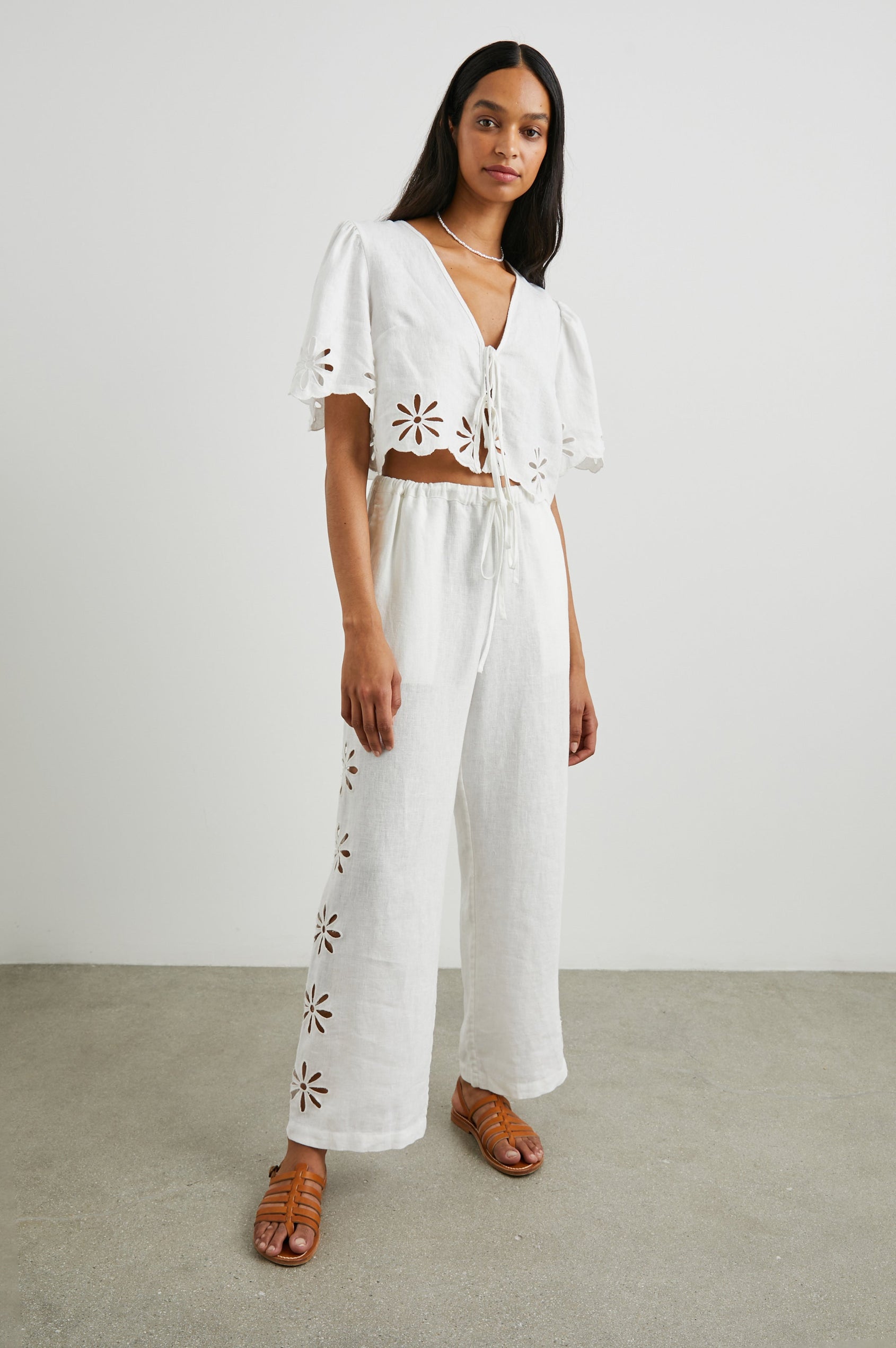 Pari Short-Sleeve Cropped Top with V Neck, Front Tie Closures, and Floral Eyelets in White Eyelet Colorway - Front Full Body View Featured on Model