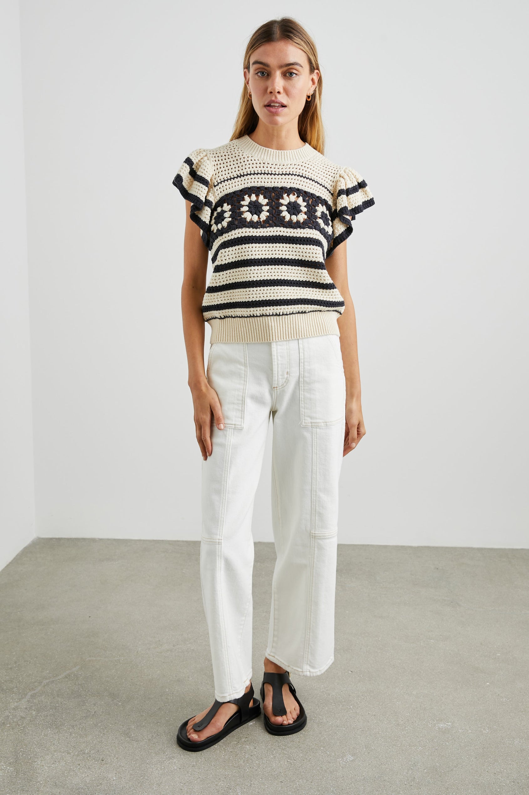 Penelope Crochet Top with Flutter Sleeves and Ribbed Hem in Oat Navy Crochet Colorway, Horizontal Stripes with contrasting knit flowers across the chest - Front Full Body View Featured on Model