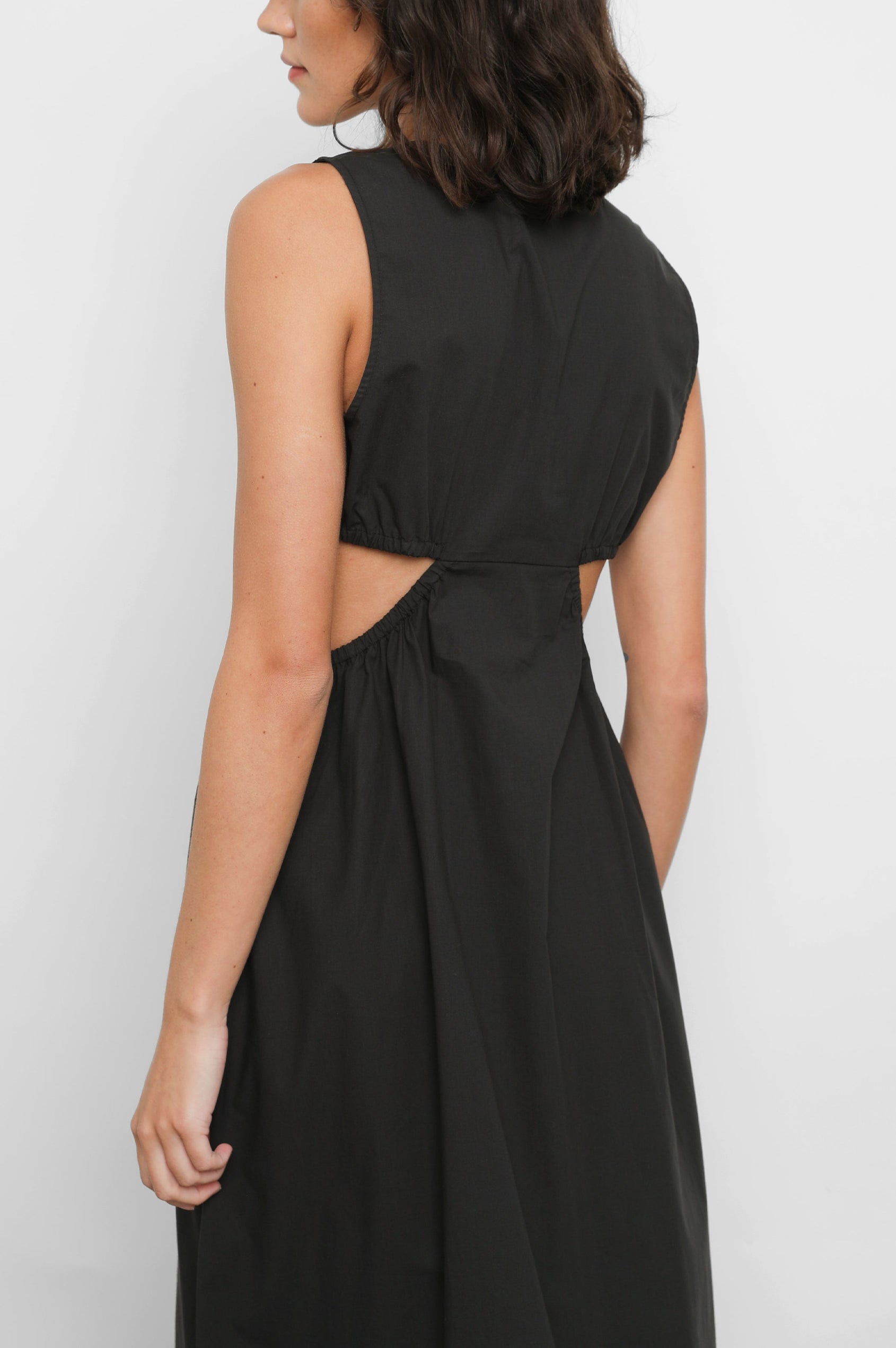 Rizo Sleeveless Midi Dress with Wide Shoulder Straps, a Deep V Neck with a Cutout, and Cutouts Beneath the Bust and Circling to the Back in Black Colorway - Back View Featured on Model