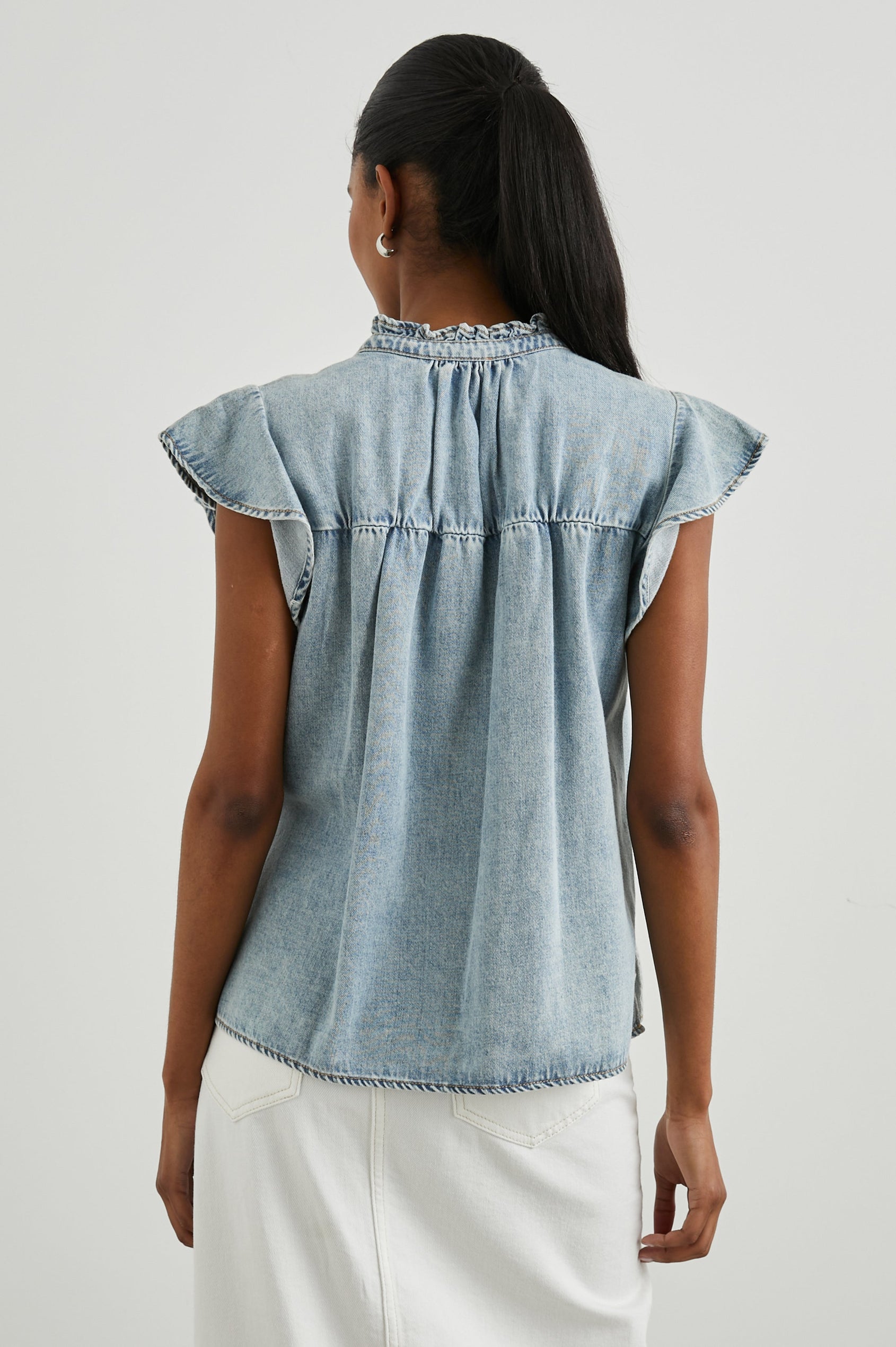 Ruthie Top with Flutter Cap Sleeves, a Ruffled Banded Collar, Buttons Down the Front, and Soft Shirring at Front Yoke in Faded Indigo Colorway - Back View Featured on Model