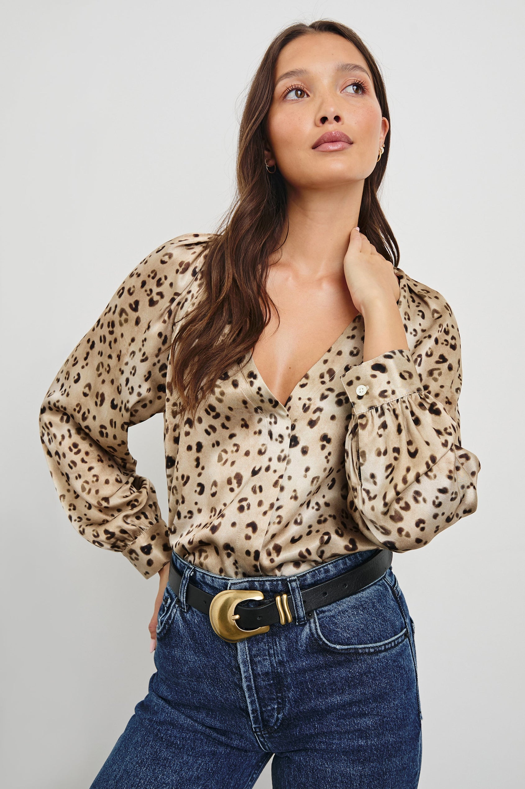 Sandra Long-Sleeve Faux Wrap Blouse with a Deep V Neck and Button Cuffs in Champagne Leopard Colorway, with brown and black spots on Champagne - Front Tucked View Featured on Model