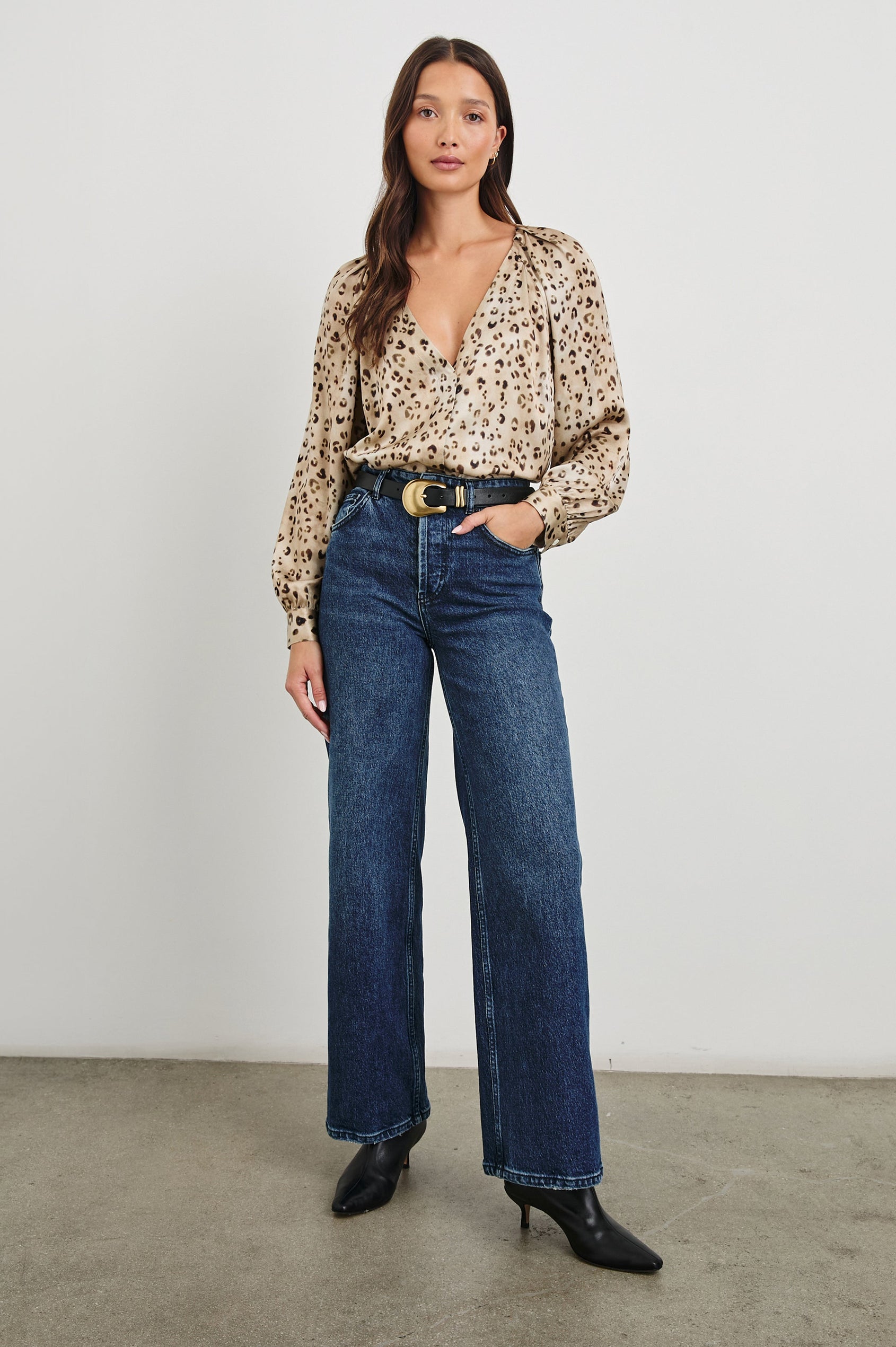 Sandra Long-Sleeve Faux Wrap Blouse with a Deep V Neck and Button Cuffs in Champagne Leopard Colorway, with brown and black spots on Champagne - Front Tucked Full Body View Featured on Model