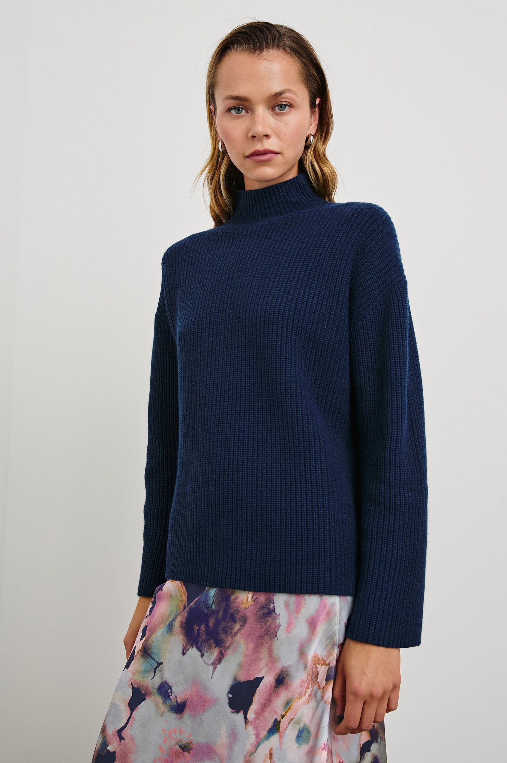 Sanna Long Sleeve Knit Sweater with a Funnel Neck and Slits at the Back of the Neck and on the Cuffs in Dark Slate Colorway - Front View Featured on Model