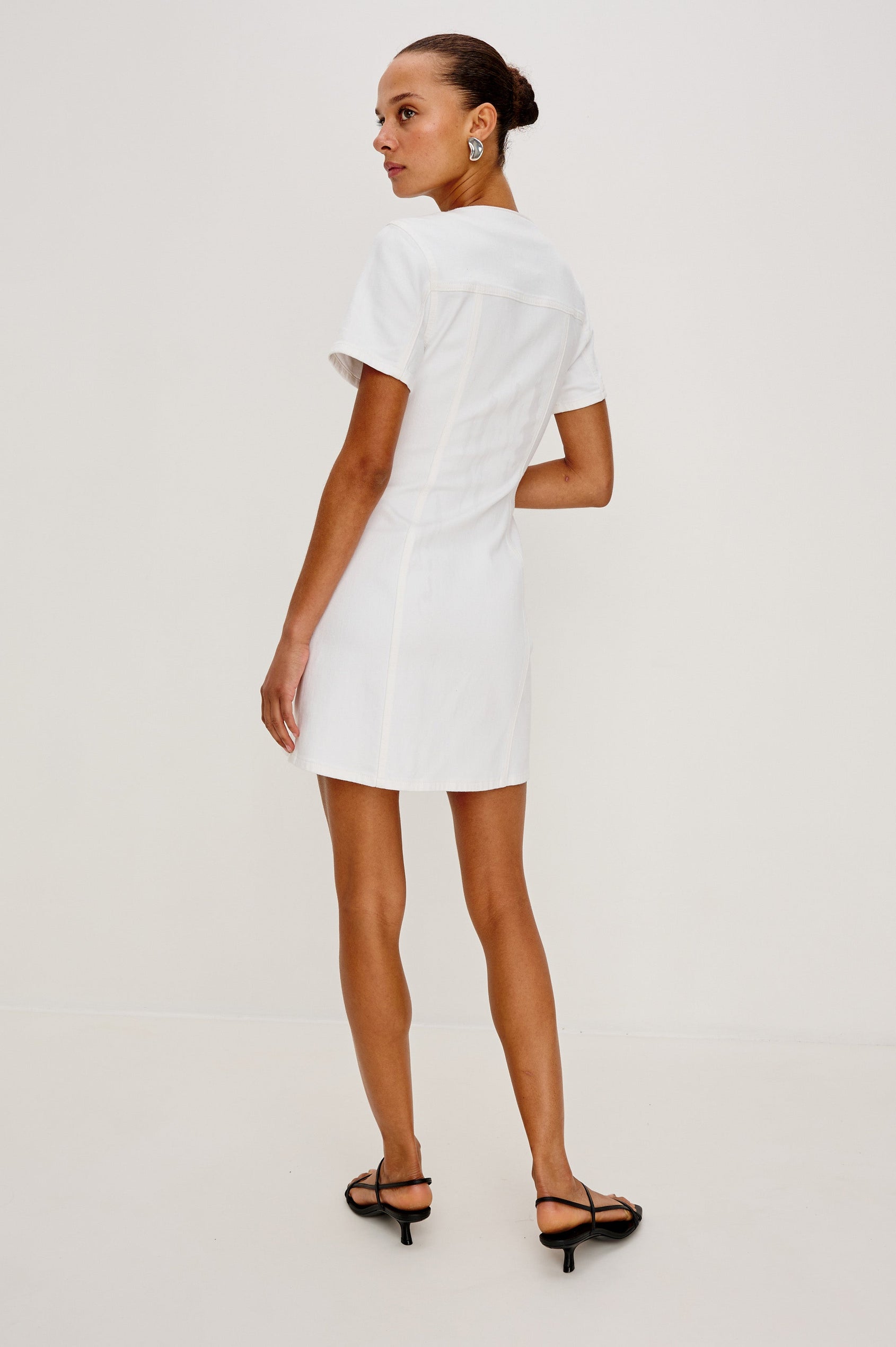 Saratoga Mini Denim Dress with a V-Neck, Short Sleeves, Button Front, Chest Flap Pockets in Salt White Colorway. Back View Shown on Model.