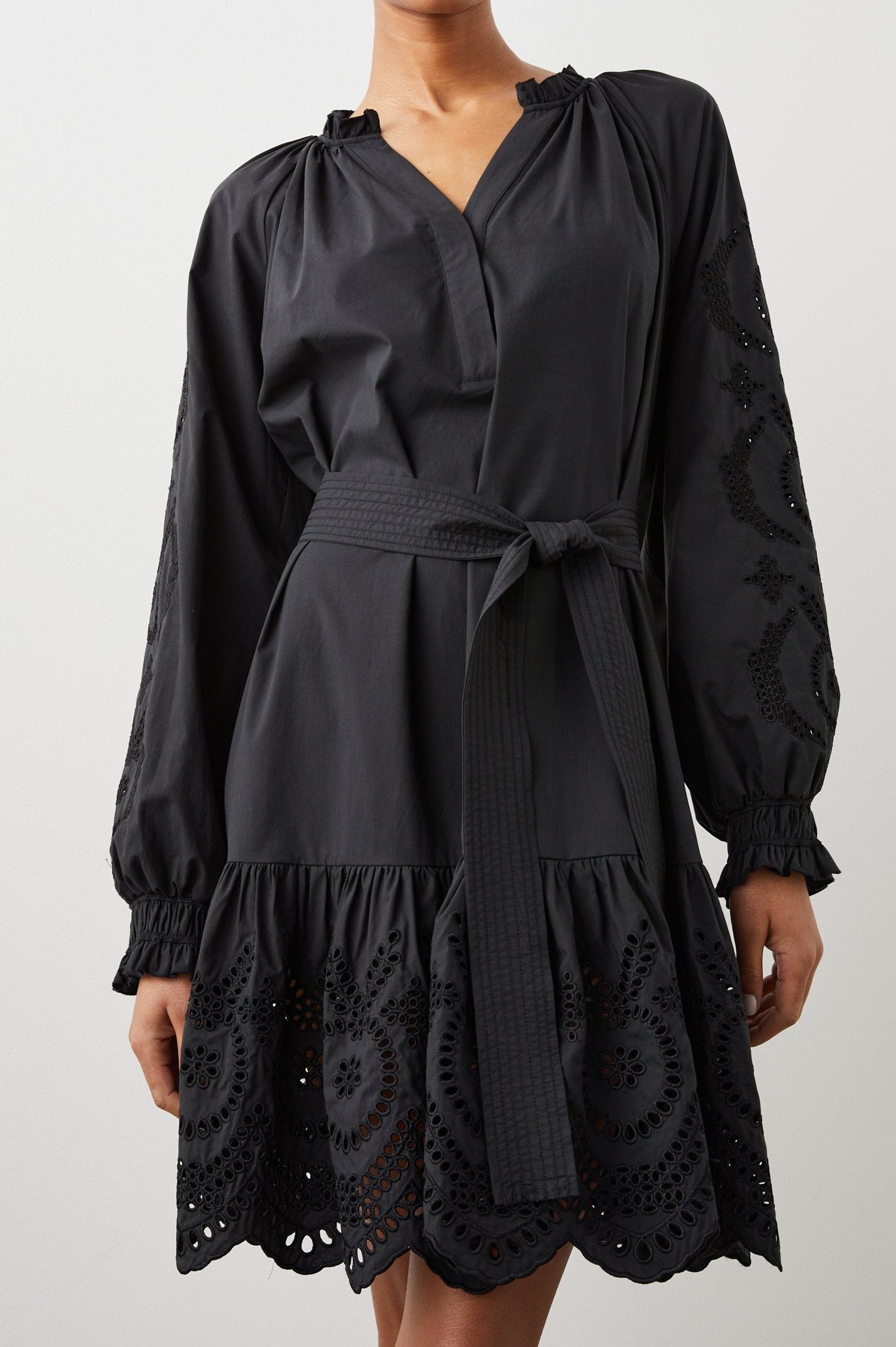 Saylor Long-Sleeve Midi Dress with a Half-Sealed Placket, a V Neck, Ruffled Collar with Shirring, a Fabric Tie Belt, and Floral and Geometric Eyelet Details in Black Eyelet Colorway - Front View Featured on Model