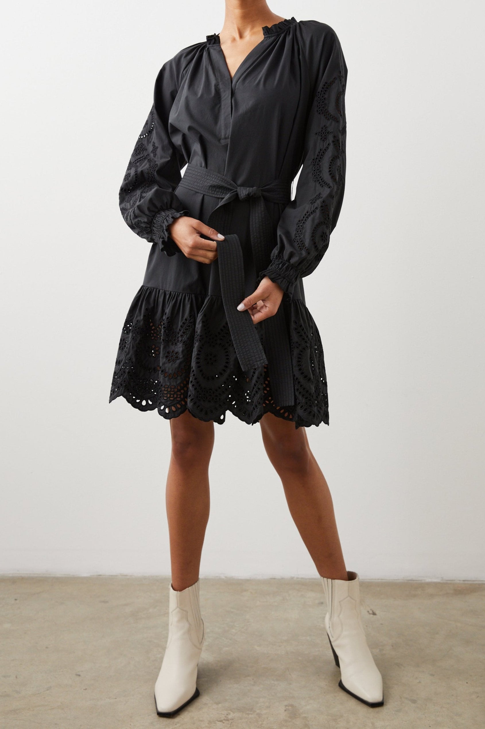 Saylor Long-Sleeve Midi Dress with a Half-Sealed Placket, a V Neck, Ruffled Collar with Shirring, a Fabric Tie Belt, and Floral and Geometric Eyelet Details in Black Eyelet Colorway - Front Full Body View Featured on Model