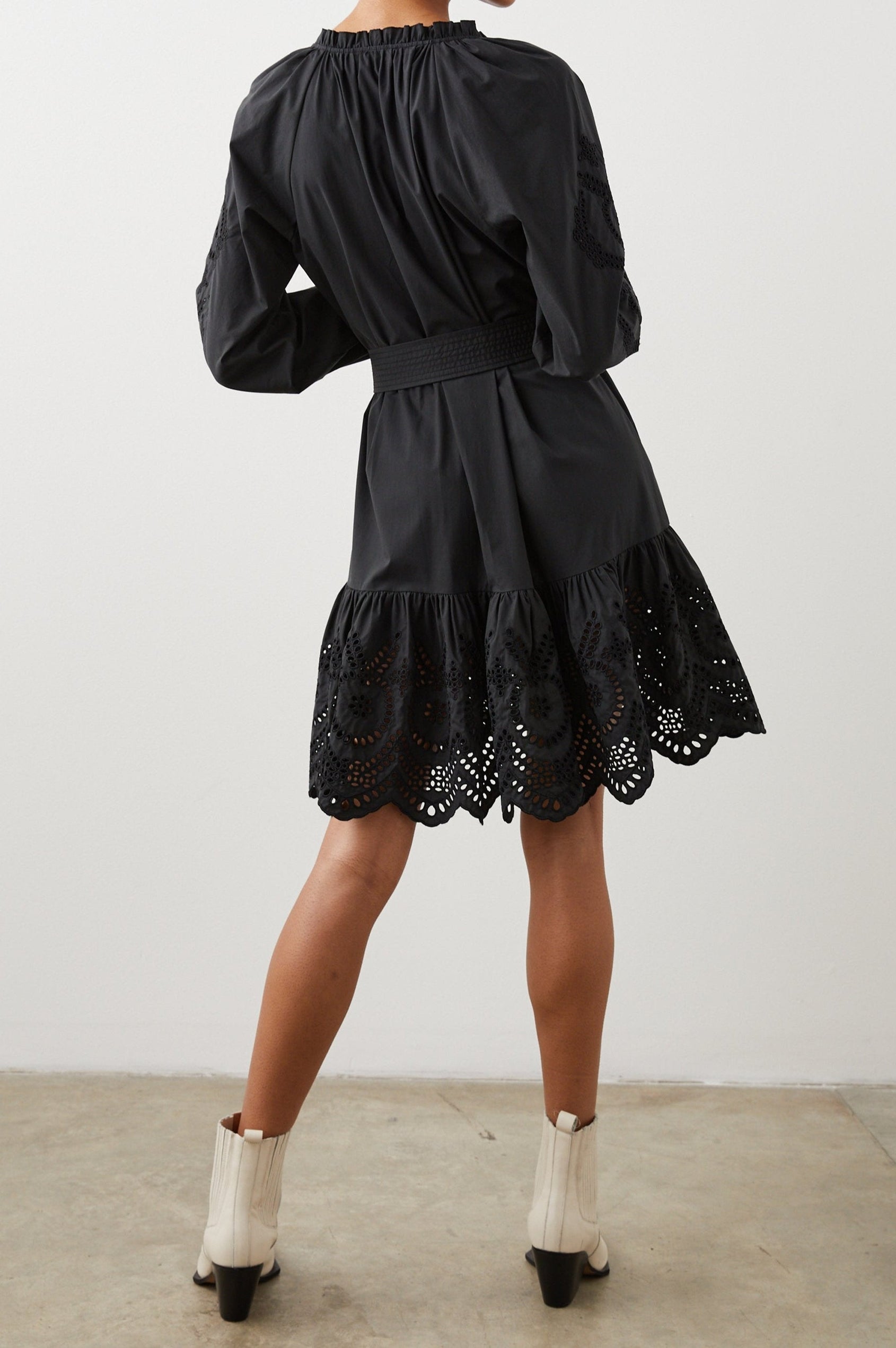 Saylor Long-Sleeve Midi Dress with a Half-Sealed Placket, a V Neck, Ruffled Collar with Shirring, a Fabric Tie Belt, and Floral and Geometric Eyelet Details in Black Eyelet Colorway - Back View Featured on Model