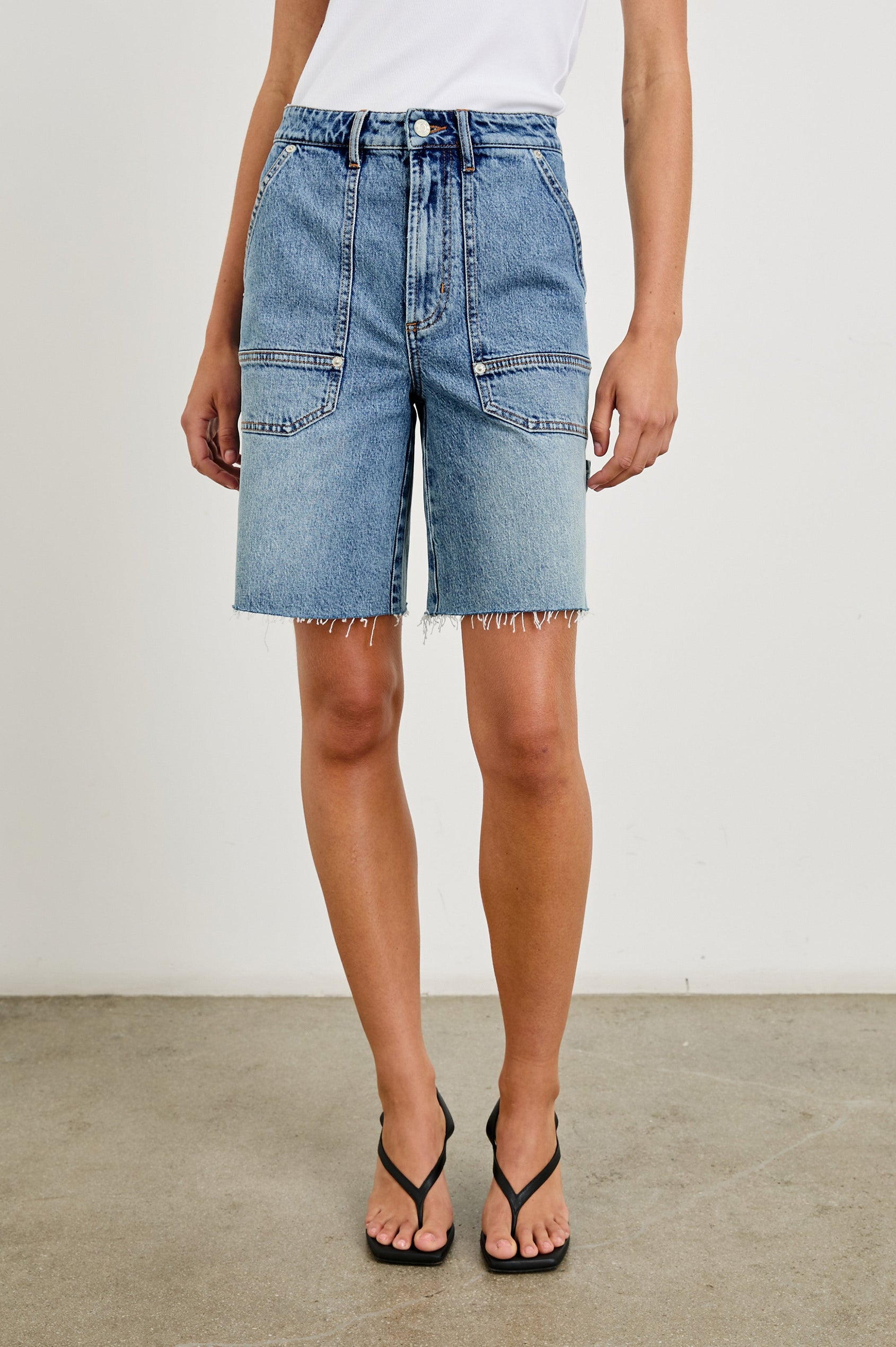 Slater high rise bermuda short with carpenter style details in Blueprint - front view on model