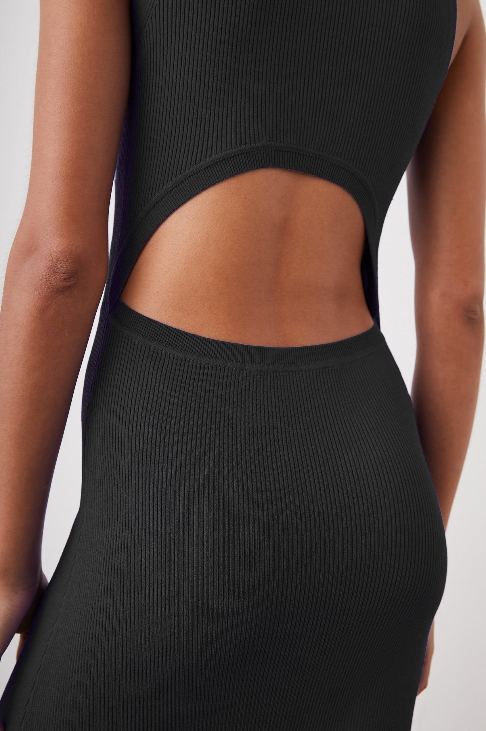 Syd Ribbed, Sleeveless Midi Dress with Wide Shoulder Straps, a Side Slit, and a Cutout that Spans the Lower Back in Black Colorway - Back View Featured on Model