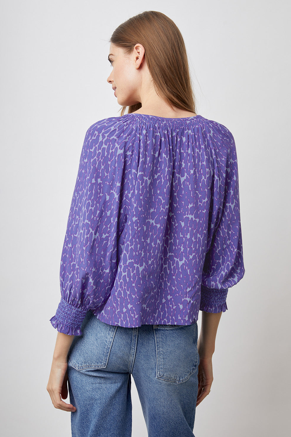 Mariah Top with Three-Quarter Sleeves, Shirred Cuffs, V-Neckline, and Buttons Down the Front in Static Leopard Print Colorway, a purple print - Back View Featured on Model
