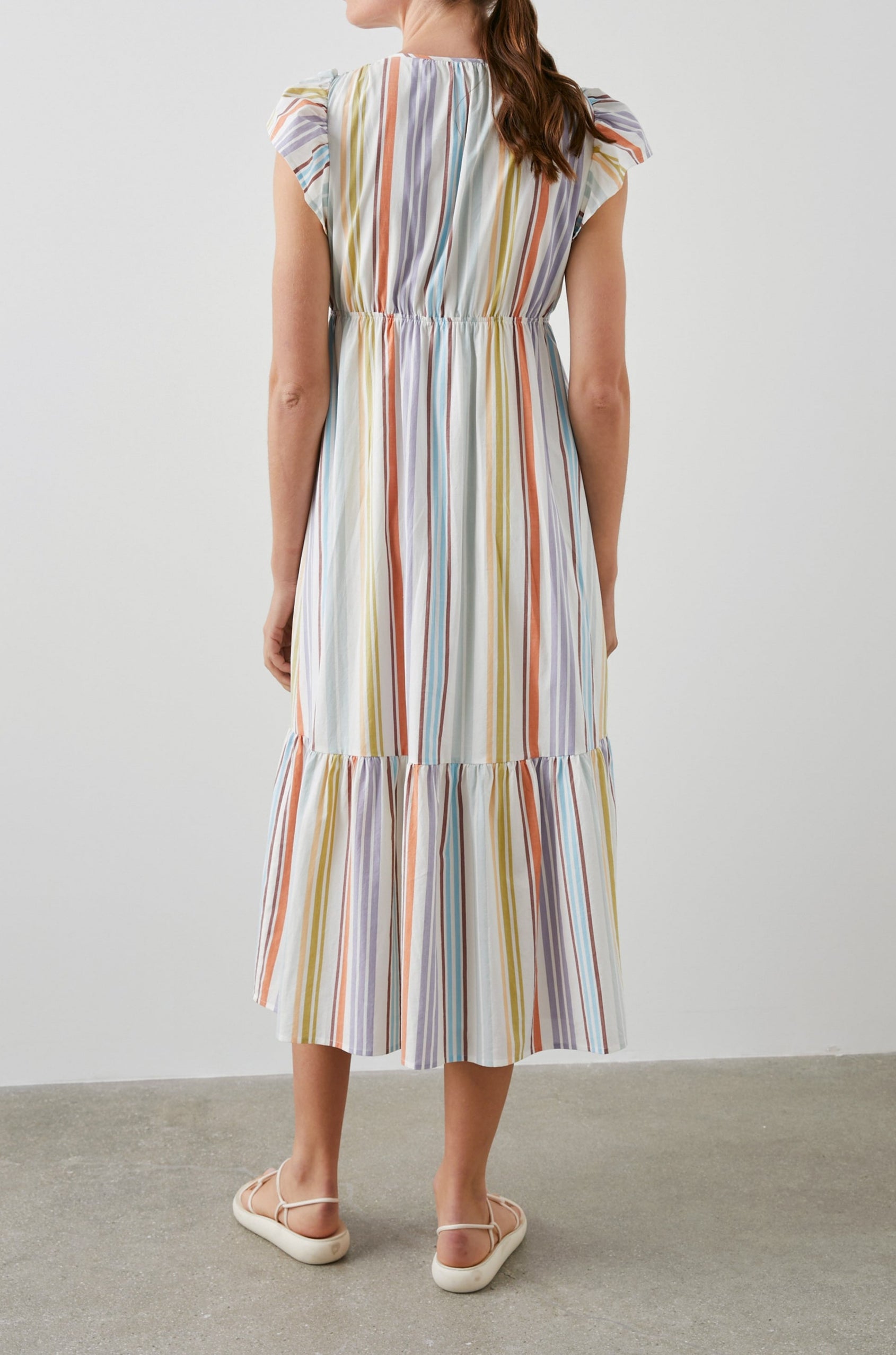 Tina Short Sleeve Midi Dress with Flutter Sleeves, a Deep V Neck with a Cutout and a Tiered Skirt in Oasis Stripe Colorway, Vertical Stripes in Green, Oranges, Purple and Blues on White - Back Full Body View Featured on Model