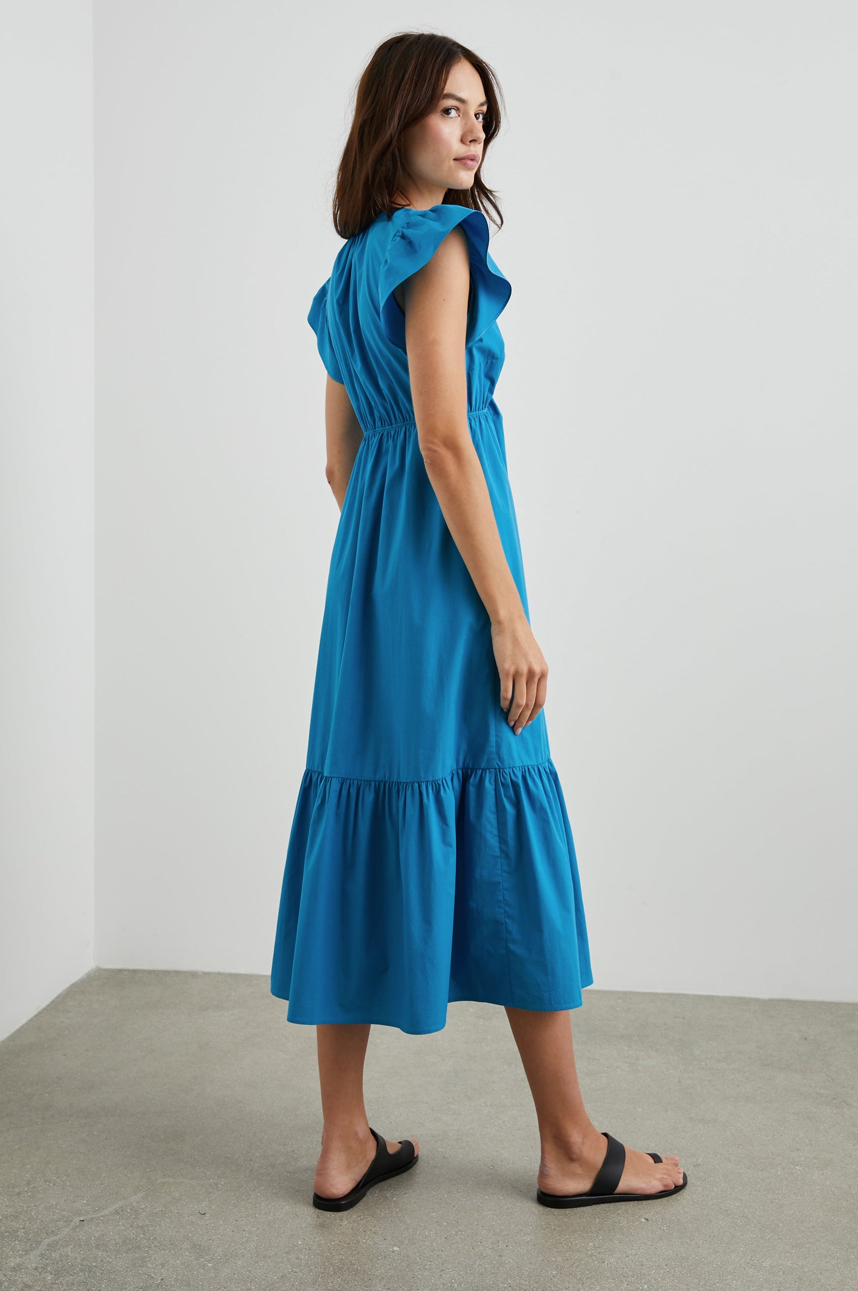 Tina Short Sleeve Midi Dress with Flutter Sleeves, a Deep V Neck with a Cutout and a Tiered Skirt in Turkish Tile Colorway, a Blue - Back Full Body View Featured on Model