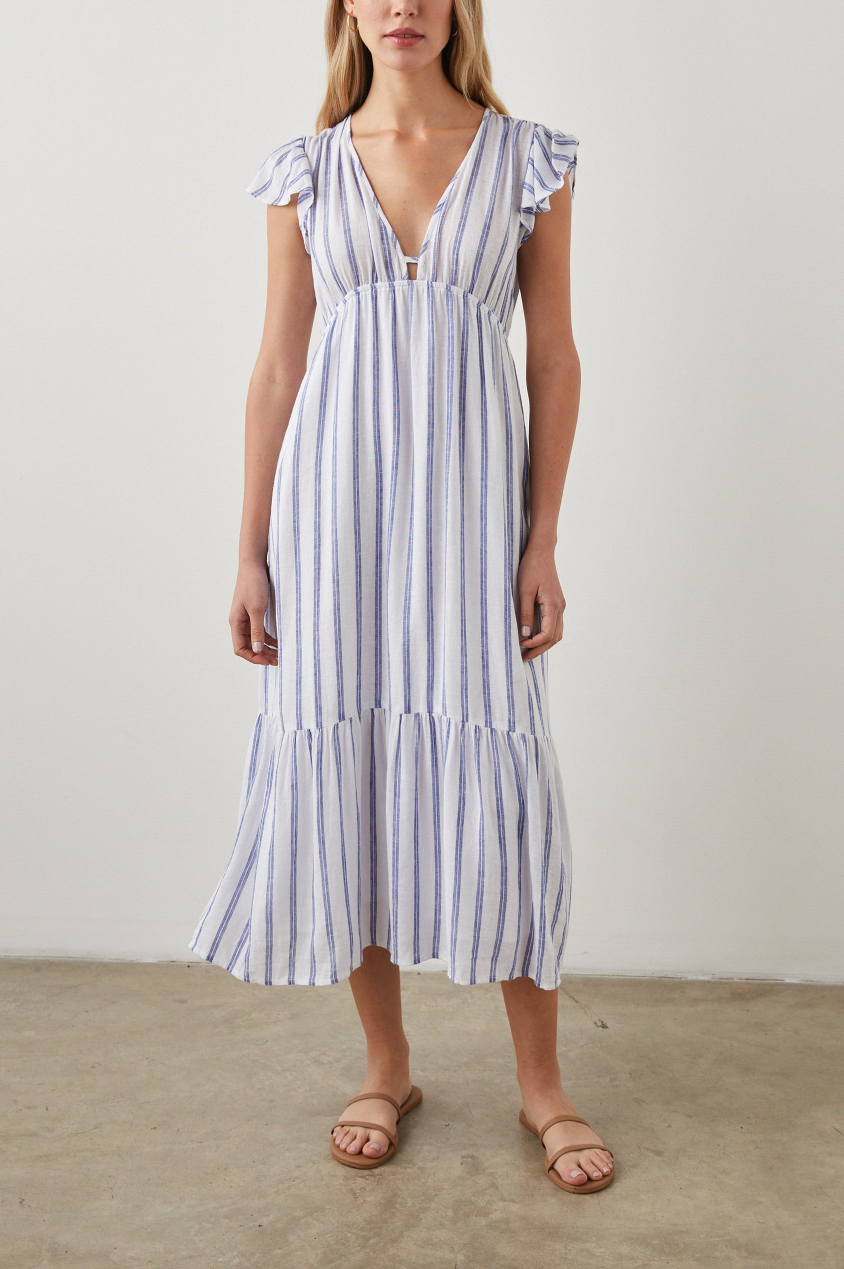 Tina Short Sleeve Midi Dress with Flutter Sleeves, a Deep V Neck with a Cutout and a Tiered Skirt in Villa Stripe Colorway, with Thin Vertical Blue Stripes on White - Front Full Body View Featured on Model