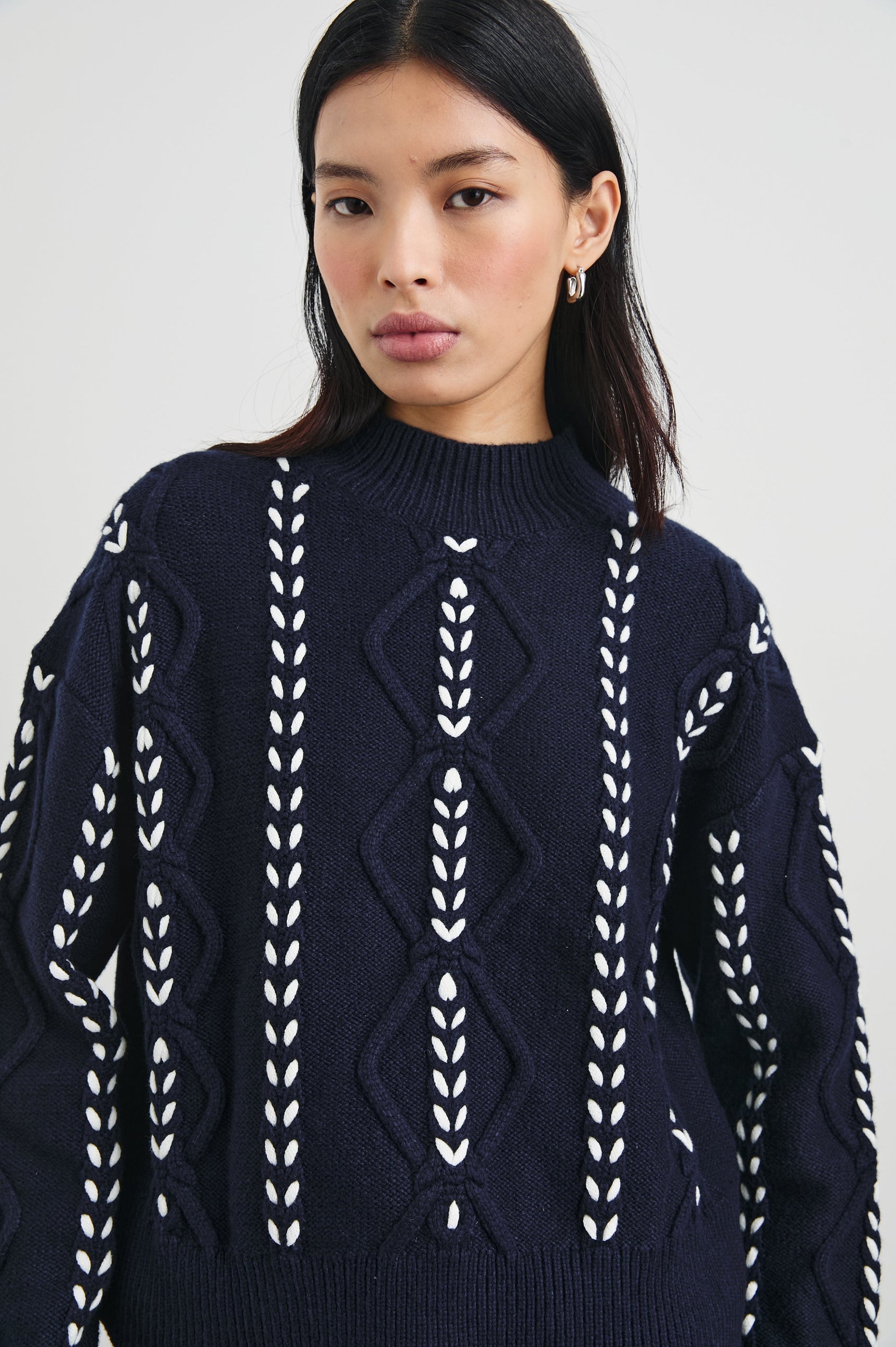 Tori Long-Sleeve Cable Sweater with a Mock Neck, Ribbed Trim in Midnight Colorway, with Thick White Vertical Stitches - Front View Featured on Model