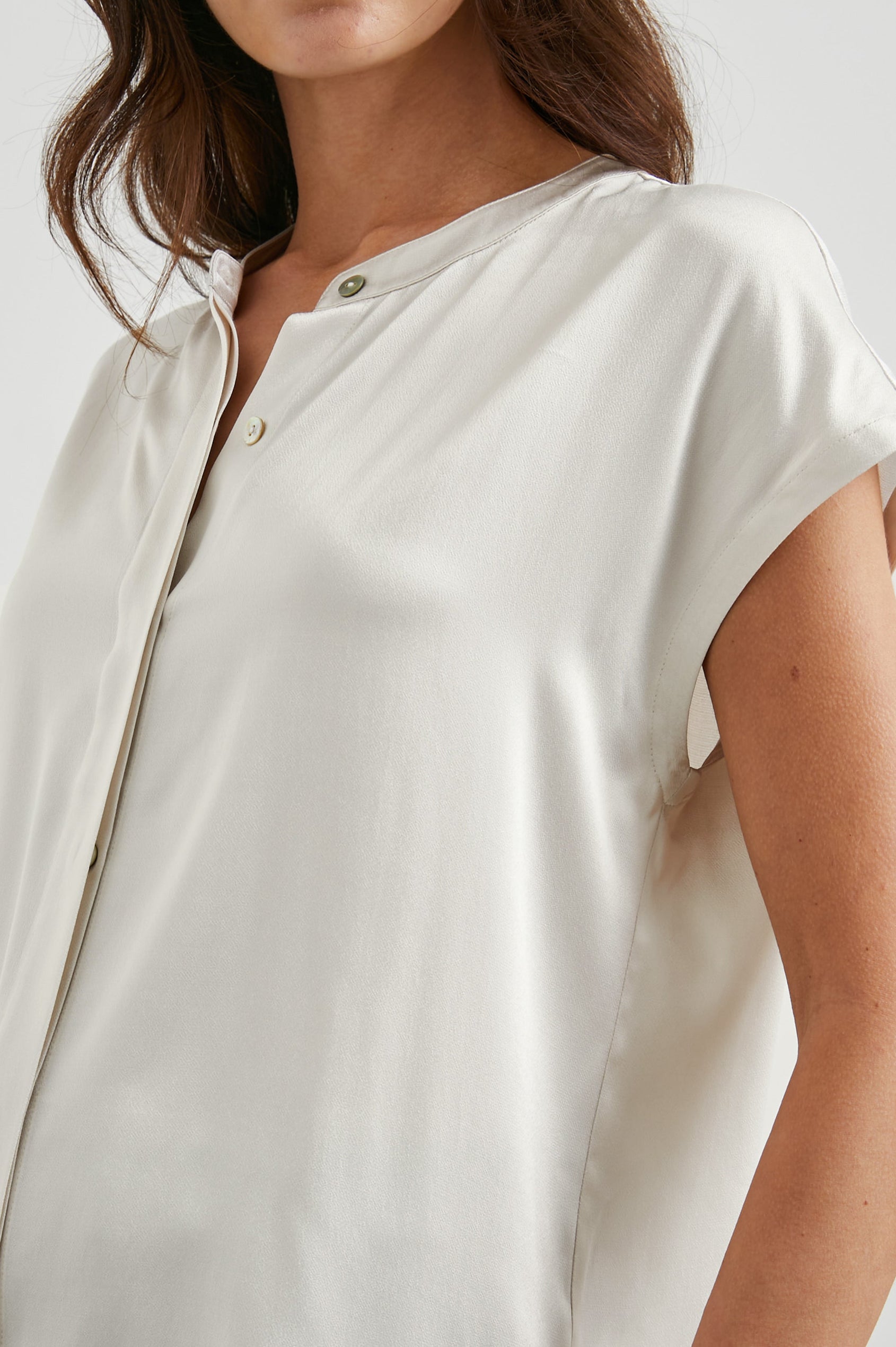 Uma Short Sleeve Top with Concealed Buttons Down the Front and Cap Sleeves in Ivory Colorway - Front View Featured on Model