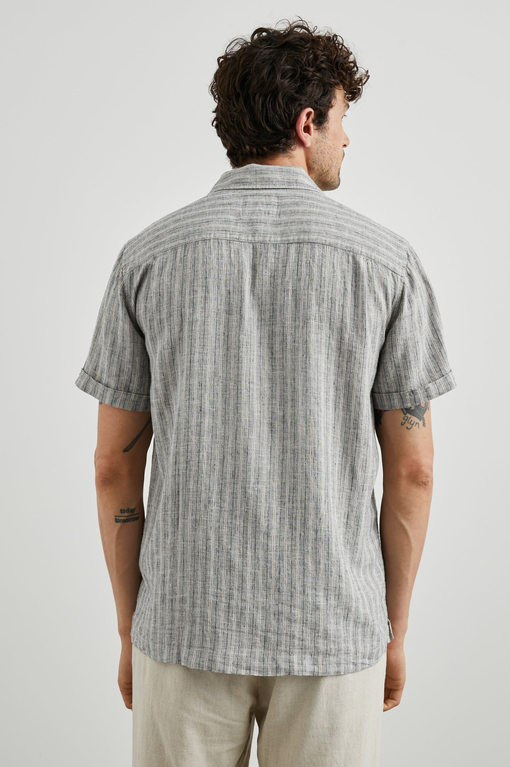 Waimea Short-Sleeve Button Up with a Chest Patch Pocket in Quinoa Navy Stripe Colorway, Thin Vertical White and Navy Stripes on Quinoa - Back View Featured on Model