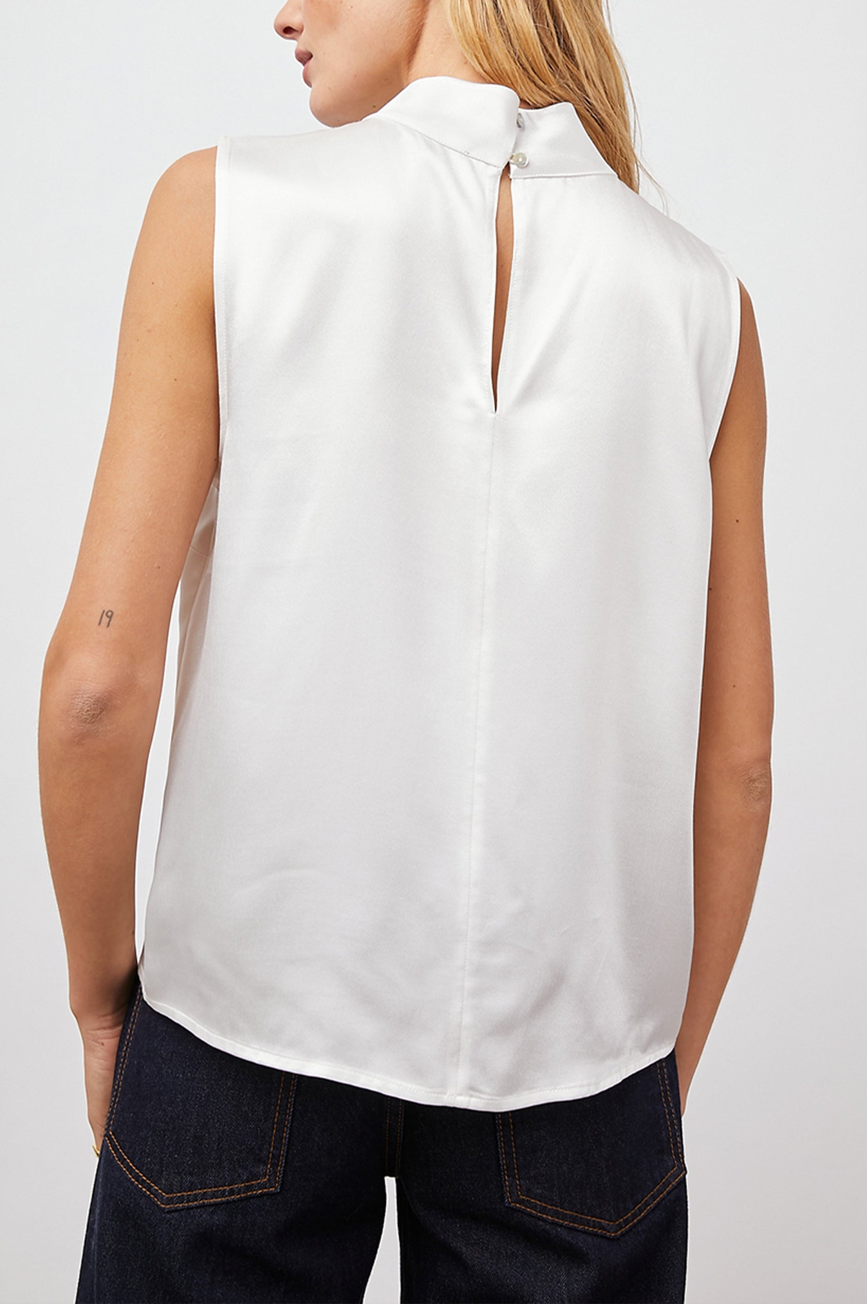 Yolie Sleeveless Tank Top with a Mock Neck and Two Button Back Neck Closure with a Keyhole in White Colorway - Back View Featured on Model