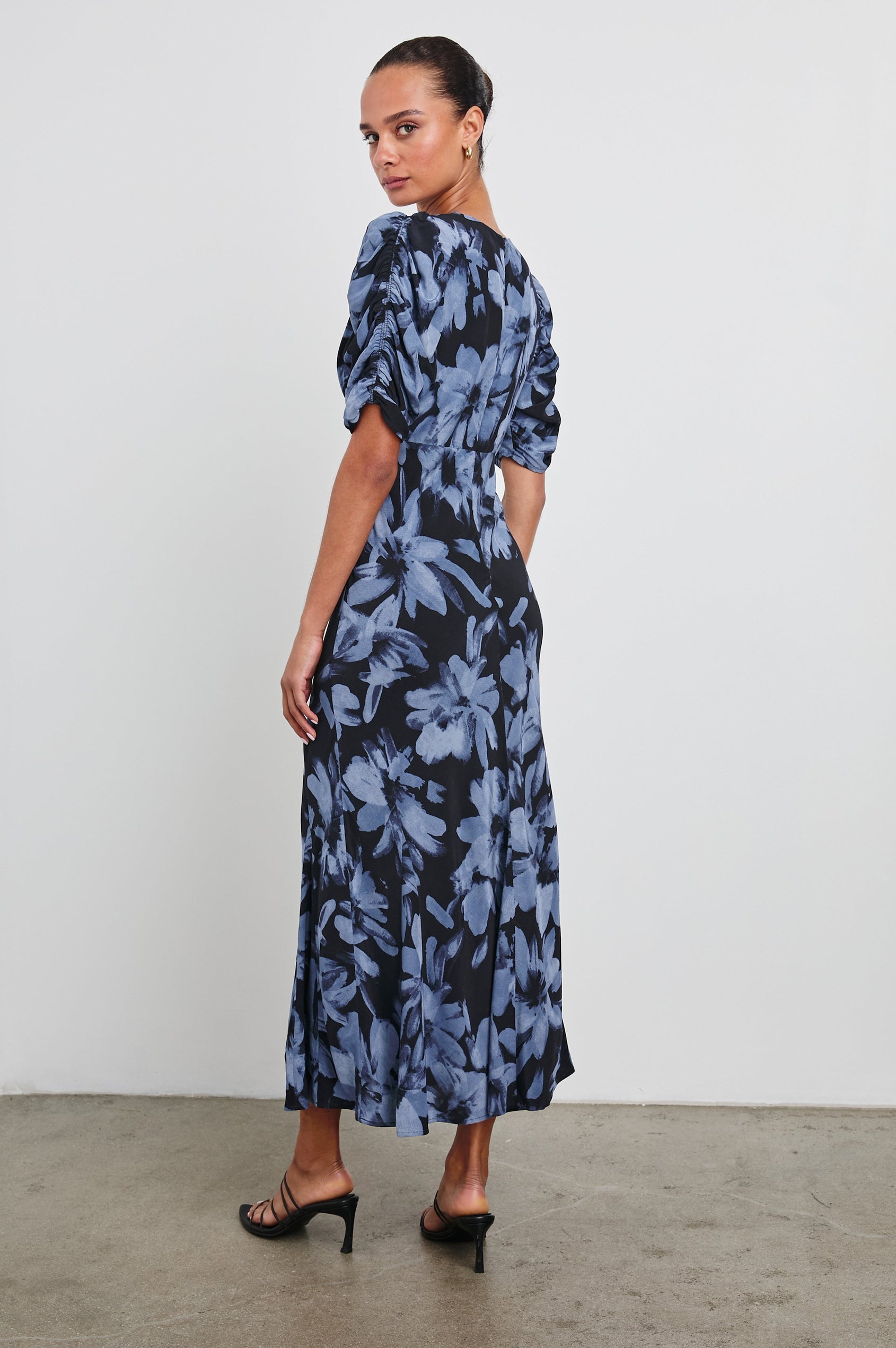 Zariah Midi Dress with Mid-Length Sleeves with Light Ruching, a Deep V Neck and an Empire Waist in Midnight Lily Colorway, with flowers in blues on midnight - Back Full Body View Featured on Model