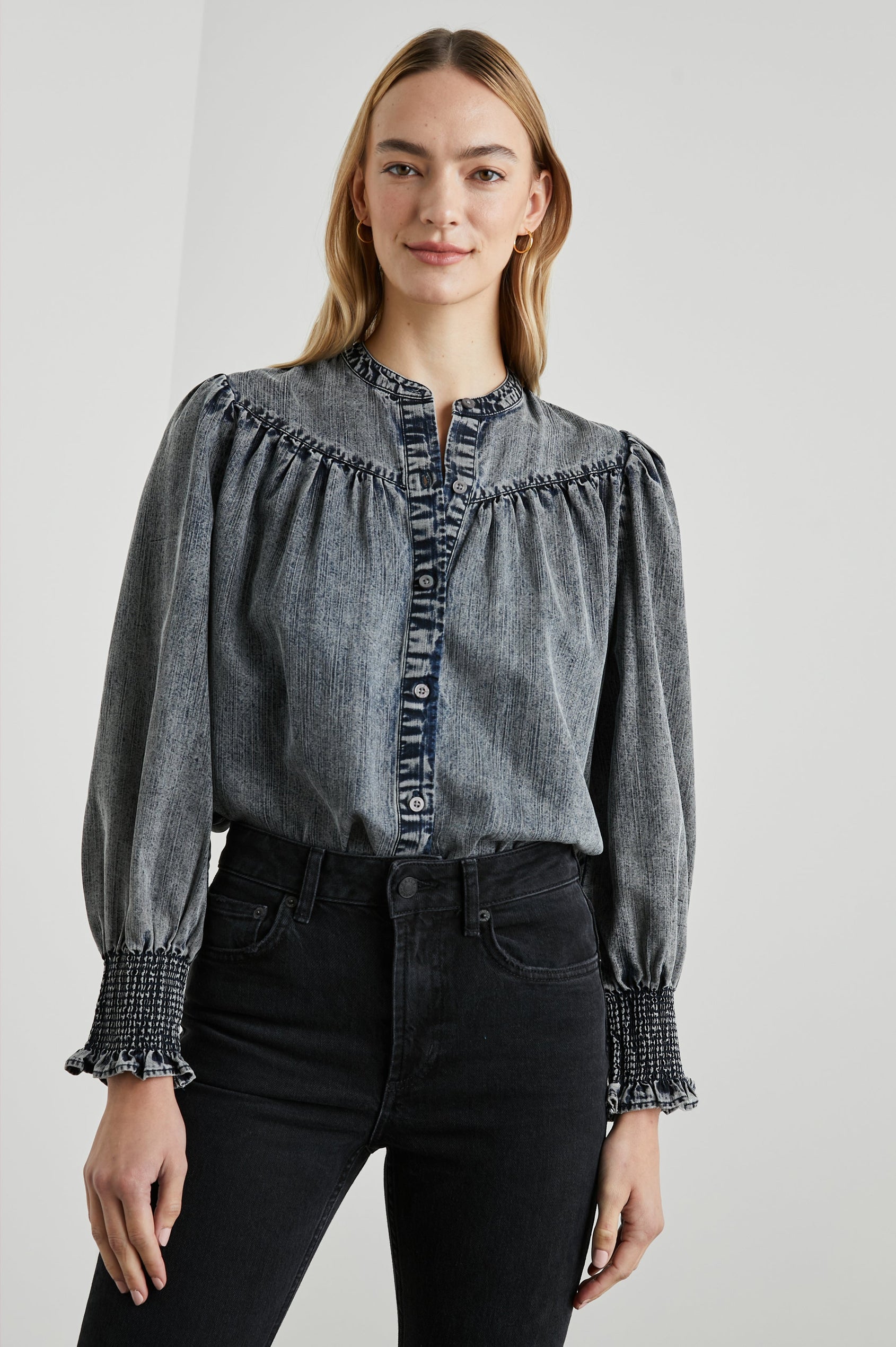 Daphne Long Sleeve Denim Shirt with Front Button Closure, Shirred and Ruffled Cuffs, and Ruching along the Yoke Seams in Ink Wash Colorway - Front Tucked View Featured on Model