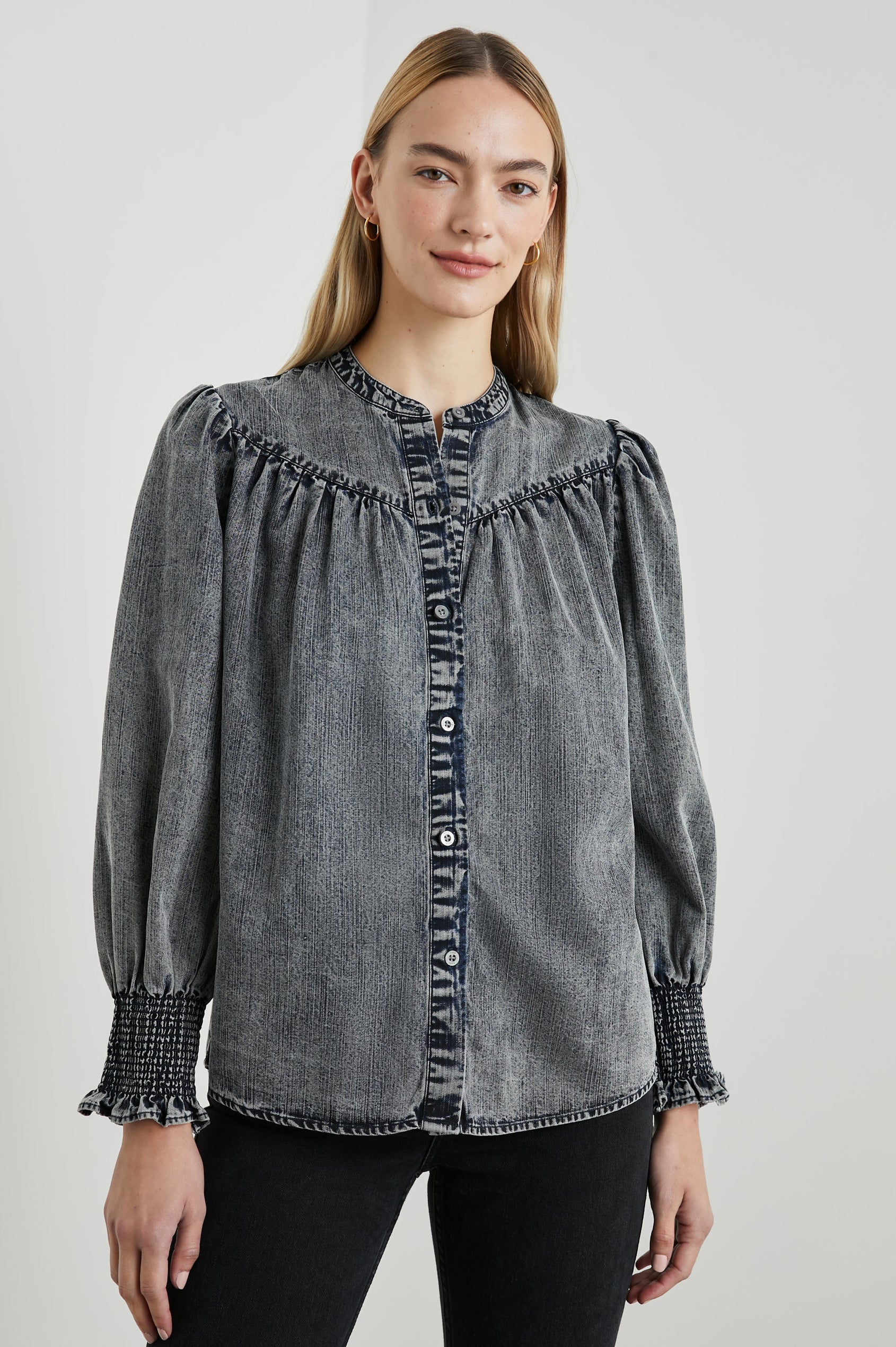 Daphne Long Sleeve Denim Shirt with Front Button Closure, Shirred and Ruffled Cuffs, and Ruching along the Yoke Seams in Ink Wash Colorway - Front View Featured on Model