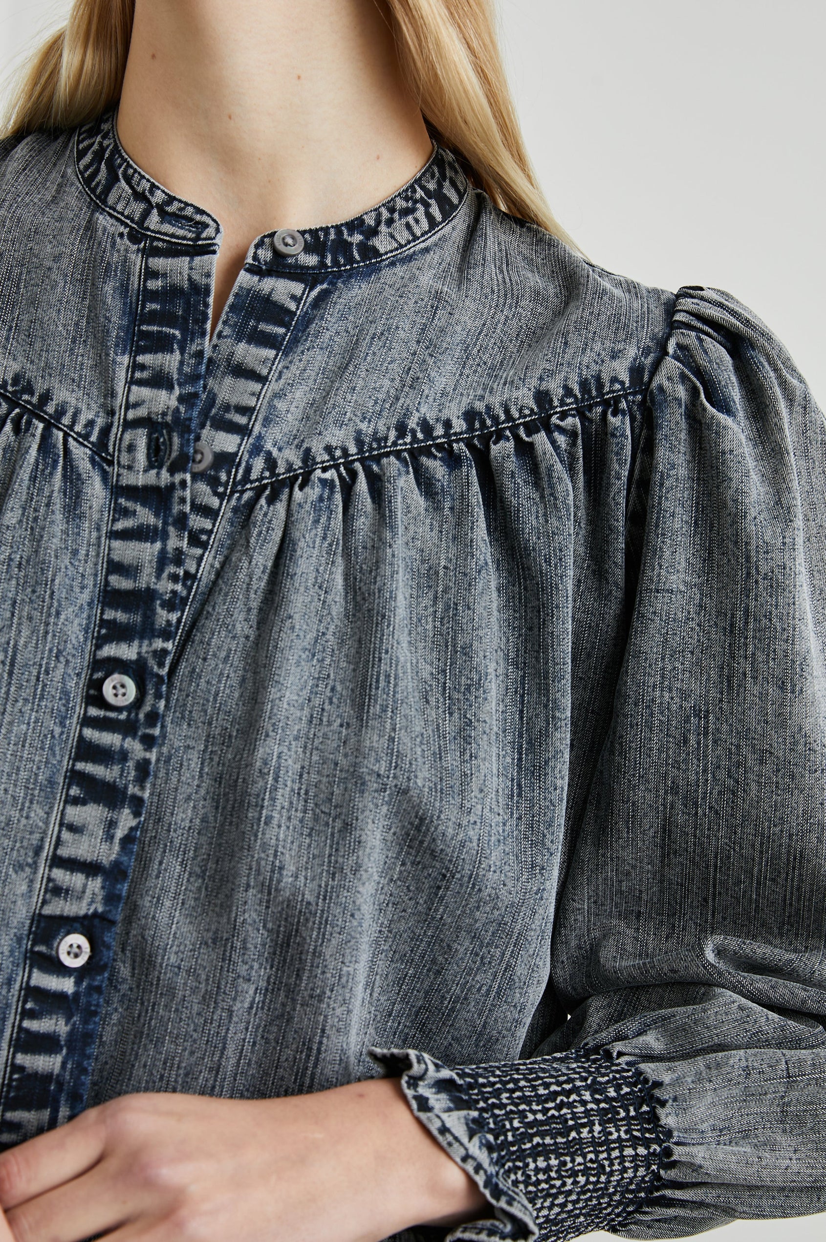 Daphne Long Sleeve Denim Shirt with Front Button Closure, Shirred and Ruffled Cuffs, and Ruching along the Yoke Seams in Ink Wash Colorway - Front View Featured on Model