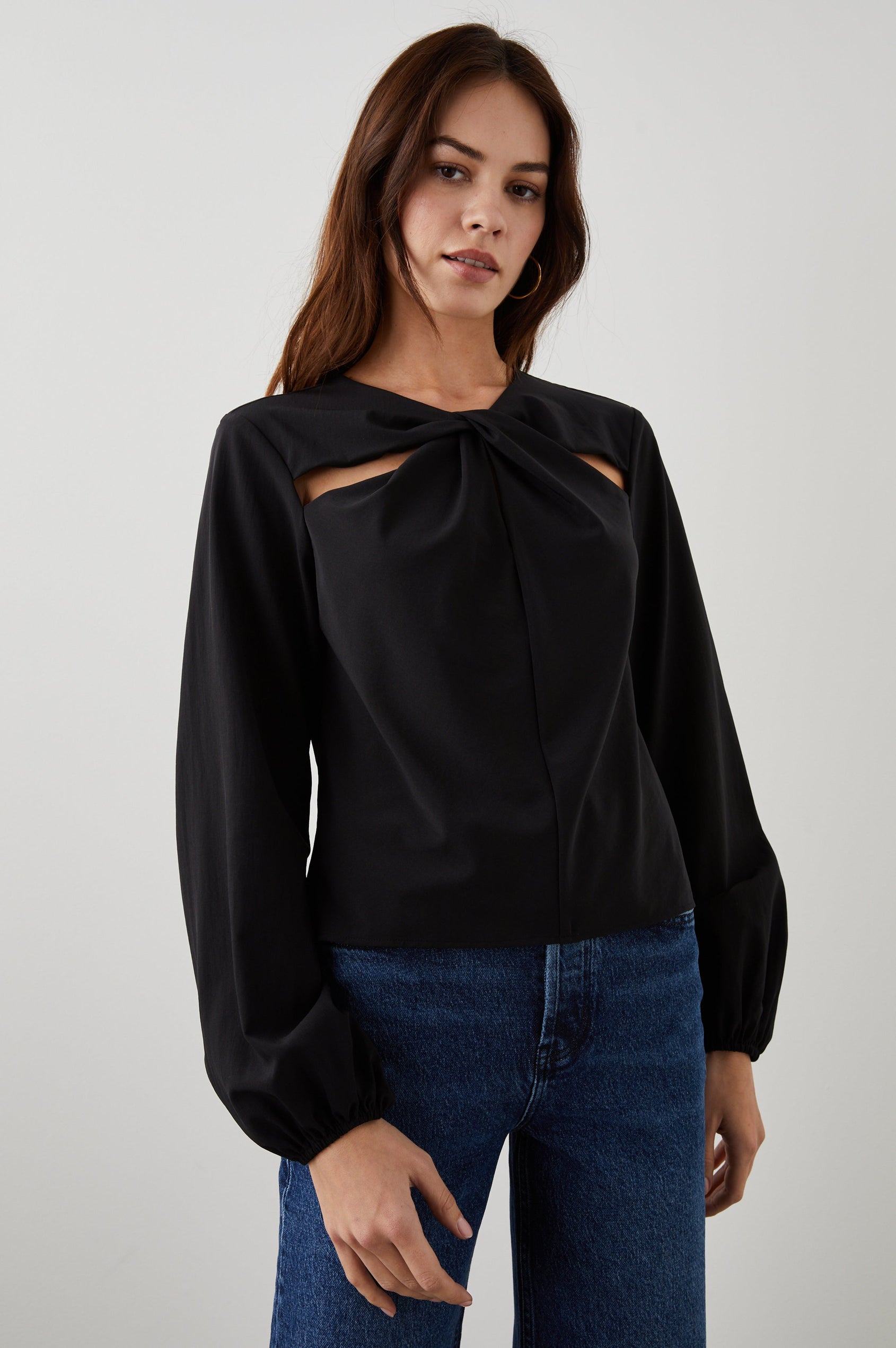 Eli Long-Sleeve Top with Twisted Fabric at the Neckline and a Cutout to the Left and Right of the Twist, a Vertical Seam Down the Front and a Keyhole at the Back in Black Colorway - Front View Featured on Model
