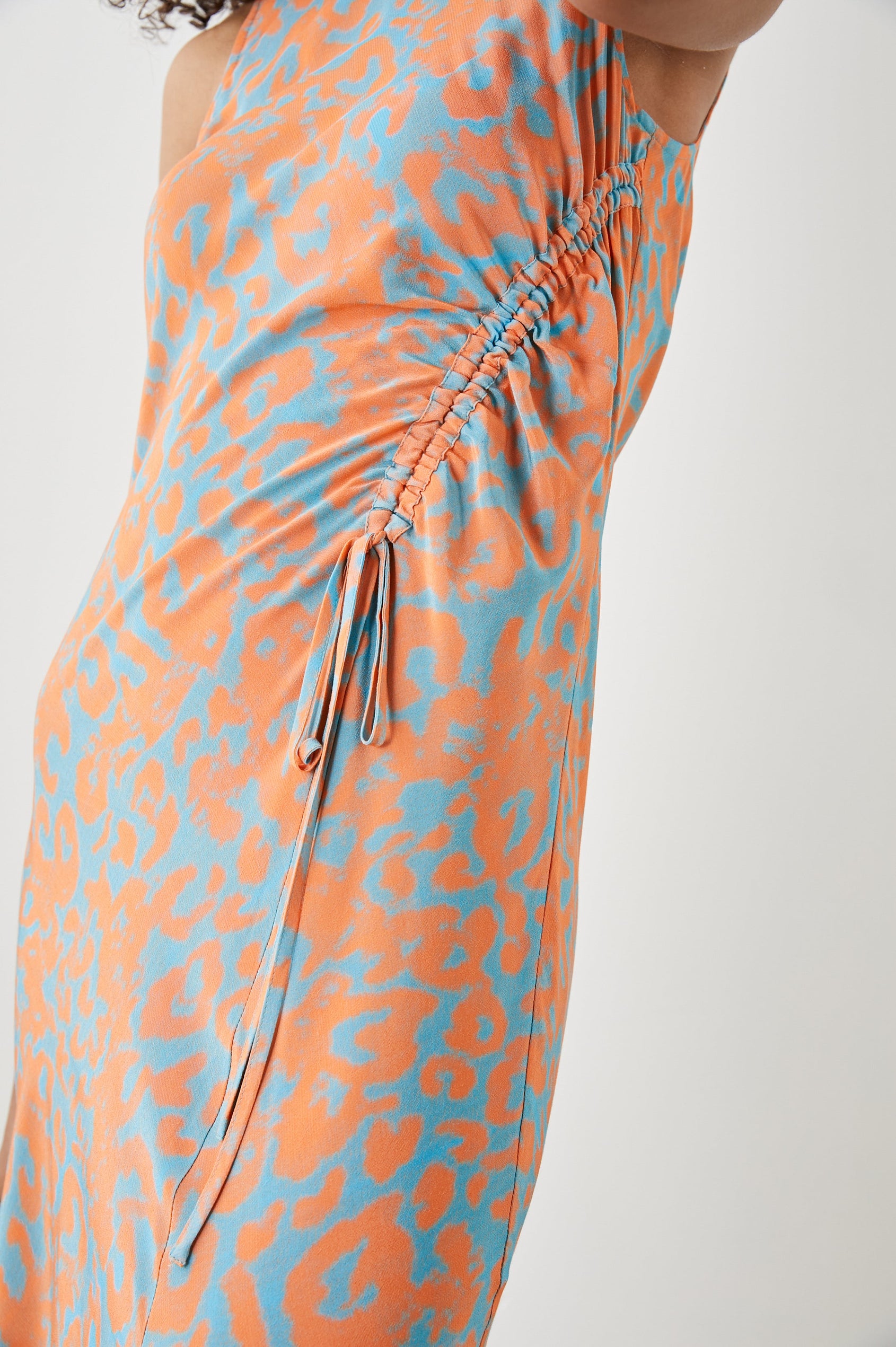 Gabriella Sleeveless Midi Dress with a Crew Neck, a Left Thigh Side Slit, a Ruched Drawstring on the Left Side and a Keyhole Button Closure at the Back in Orange Diffused Cheetah Colorway, Orange Spots on Blue - Front View Featured on Model