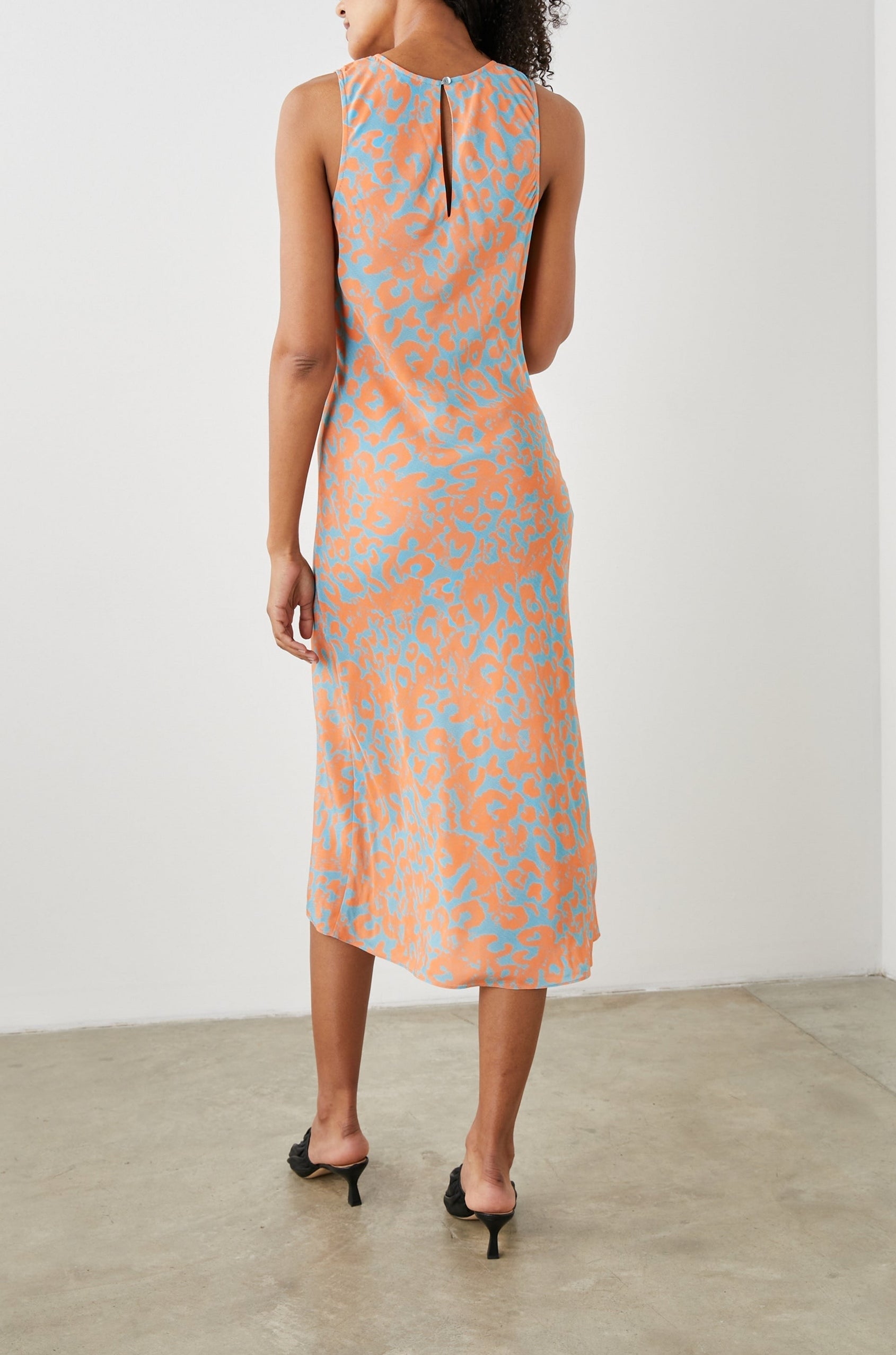 Gabriella Sleeveless Midi Dress with a Crew Neck, a Left Thigh Side Slit, a Ruched Drawstring on the Left Side and a Keyhole Button Closure at the Back in Orange Diffused Cheetah Colorway, Orange Spots on Blue - Back Full Body View Featured on Model