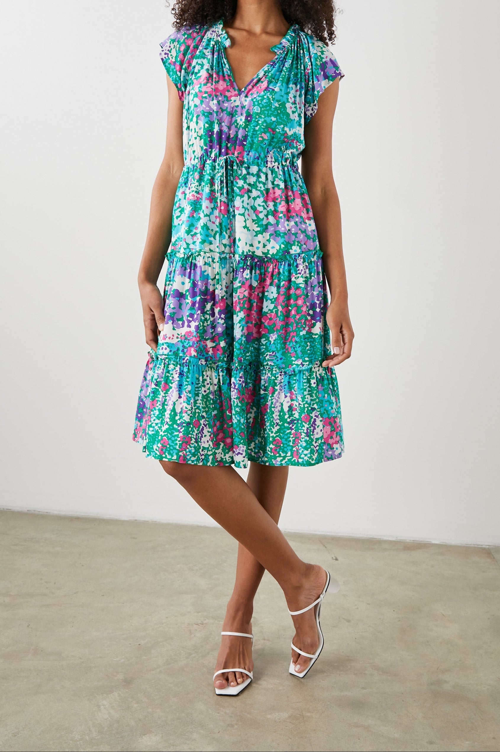 Juni Short Sleeve Midi Dress with a V Neck, Light Ruching along the Neckline, a Drawstring Waist, and a Tiered Skirt in Gardenia Floral Colorway, in Greens, Blues, Purples, Pinks and White - Front Full Body View Featured on Model