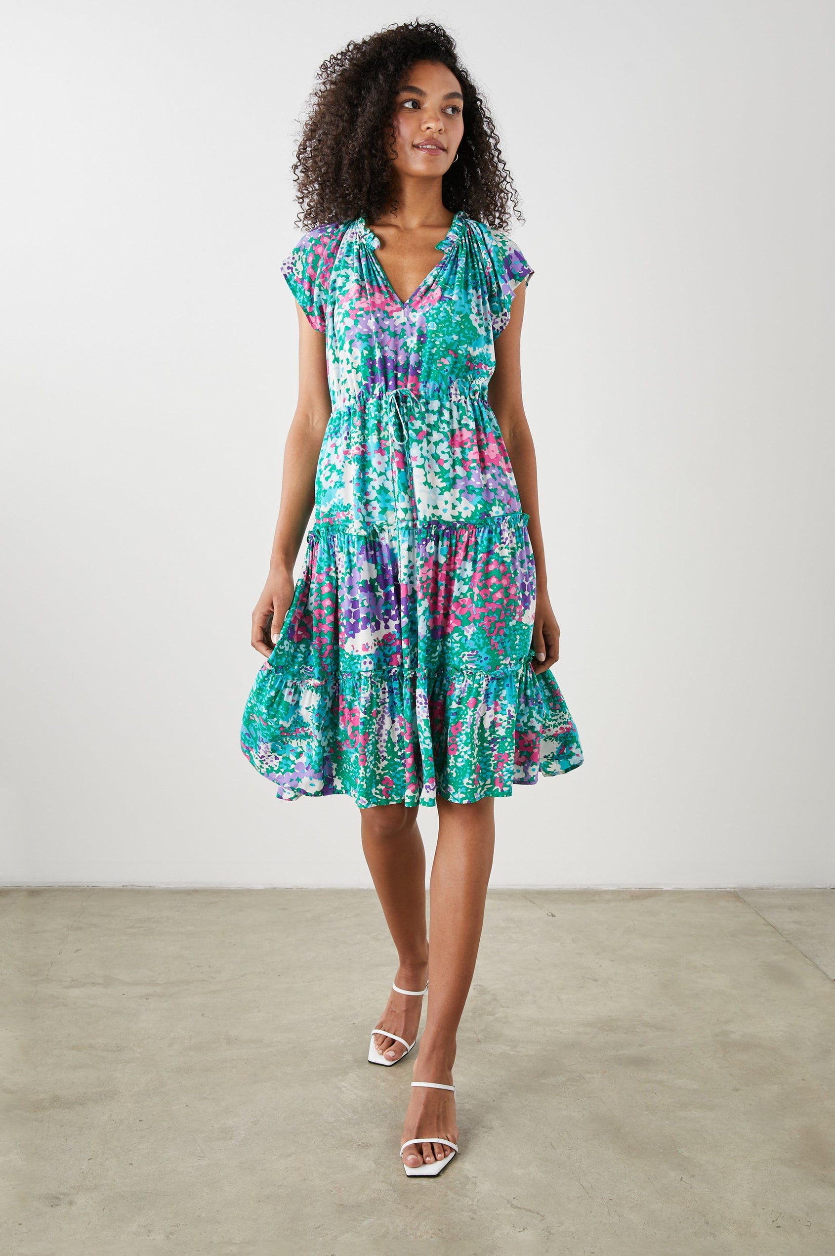 Juni Short Sleeve Midi Dress with a V Neck, Light Ruching along the Neckline, a Drawstring Waist, and a Tiered Skirt in Gardenia Floral Colorway, in Greens, Blues, Purples, Pinks and White - Front View Featured on Model