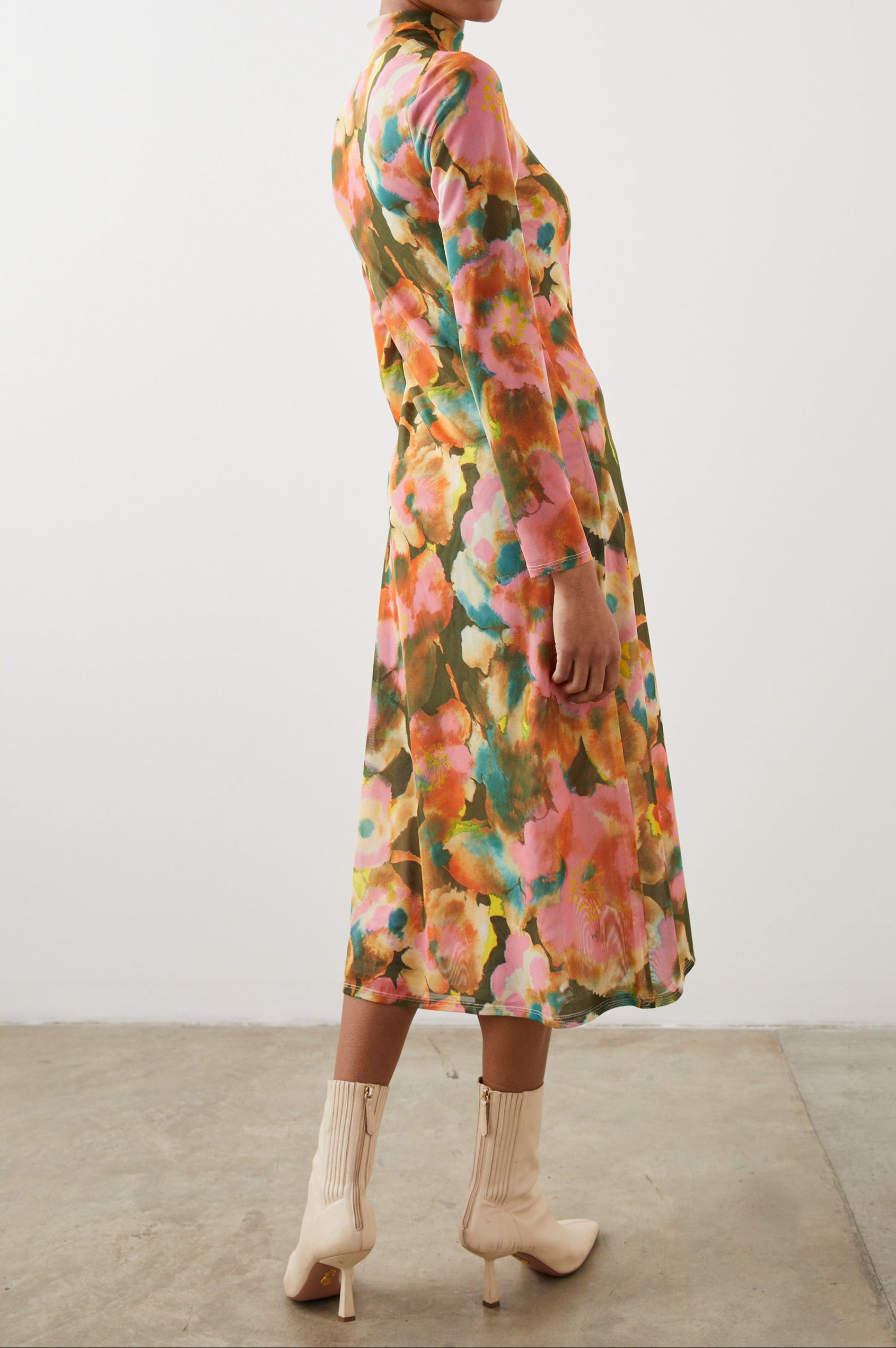 Mona Long Sleeve Midi Dress with a Mock Neck, a Side Slit and Adjustable Ruching along the Left Side with a Drawstring in Terra Floral Colorway, Flowers in Pinks, Browns, Yellows and Blues on Olive - Back Full Body View Featured on Model