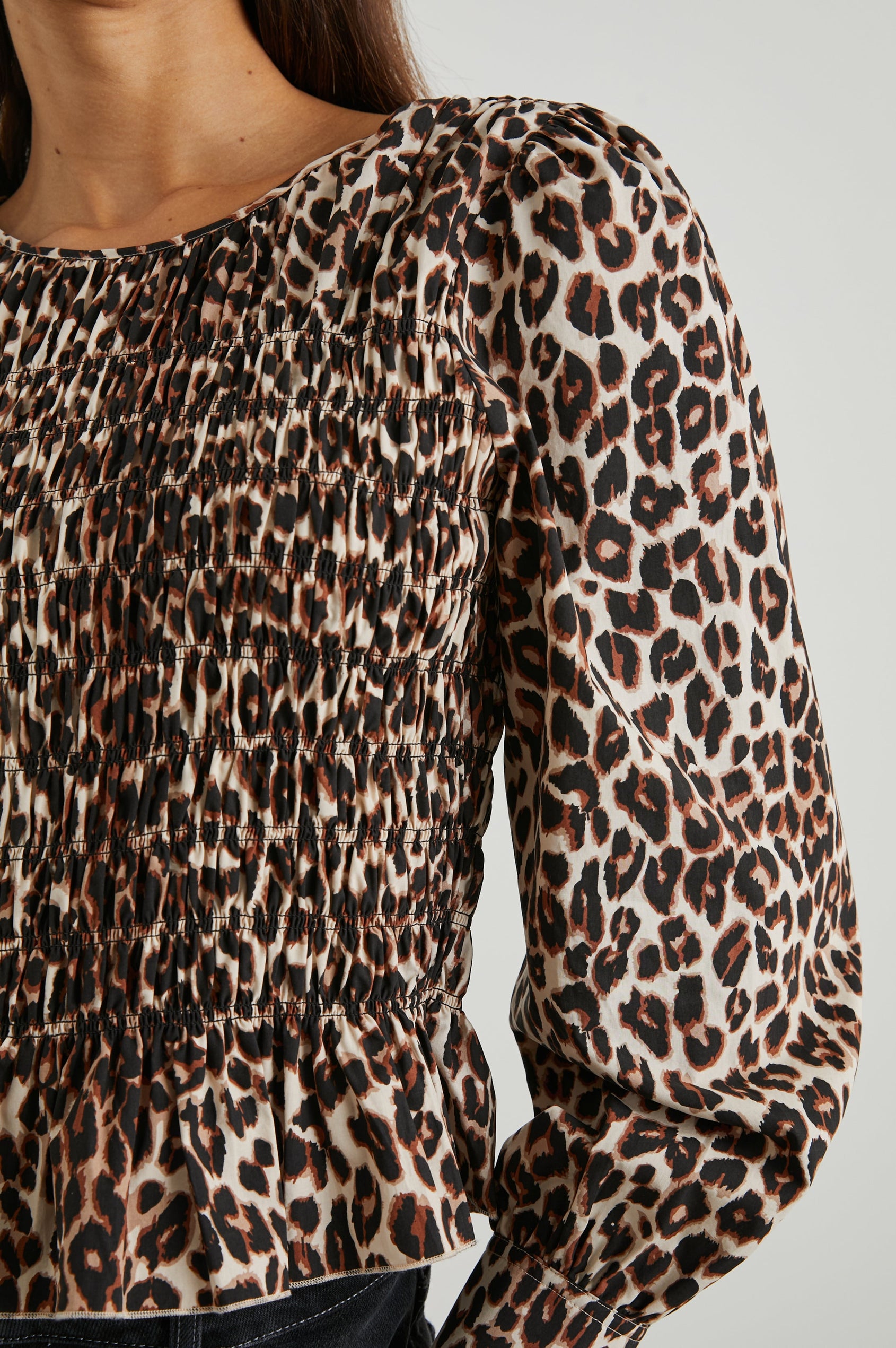 Tari Long-Sleeve Top with Shirring Across the Bodice, a Ruffled Hem, a Scoop Neck and Button Cuffs in Nala Colorway, Brown and Black Spots on White - Front View Featured on Model